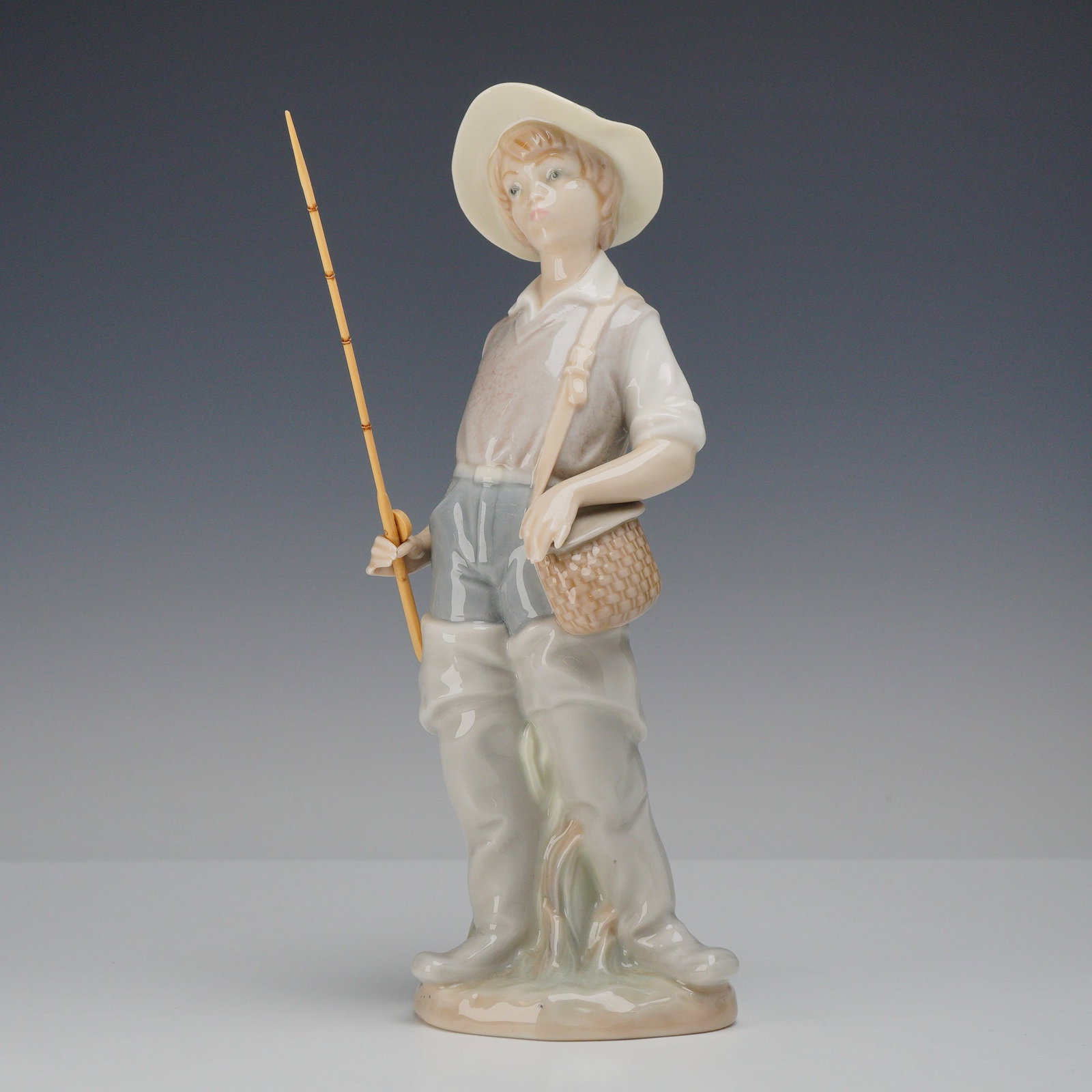 Lladro Porcelain Figurine, Going Fishing 1004809: A Lladro fine porcelain figurine titled Fisherboy, also known by the Spanish title Pescadorcito con caña, model number 4809. Designed by artist Salvador Furio, this piece was first issued in 1972 and