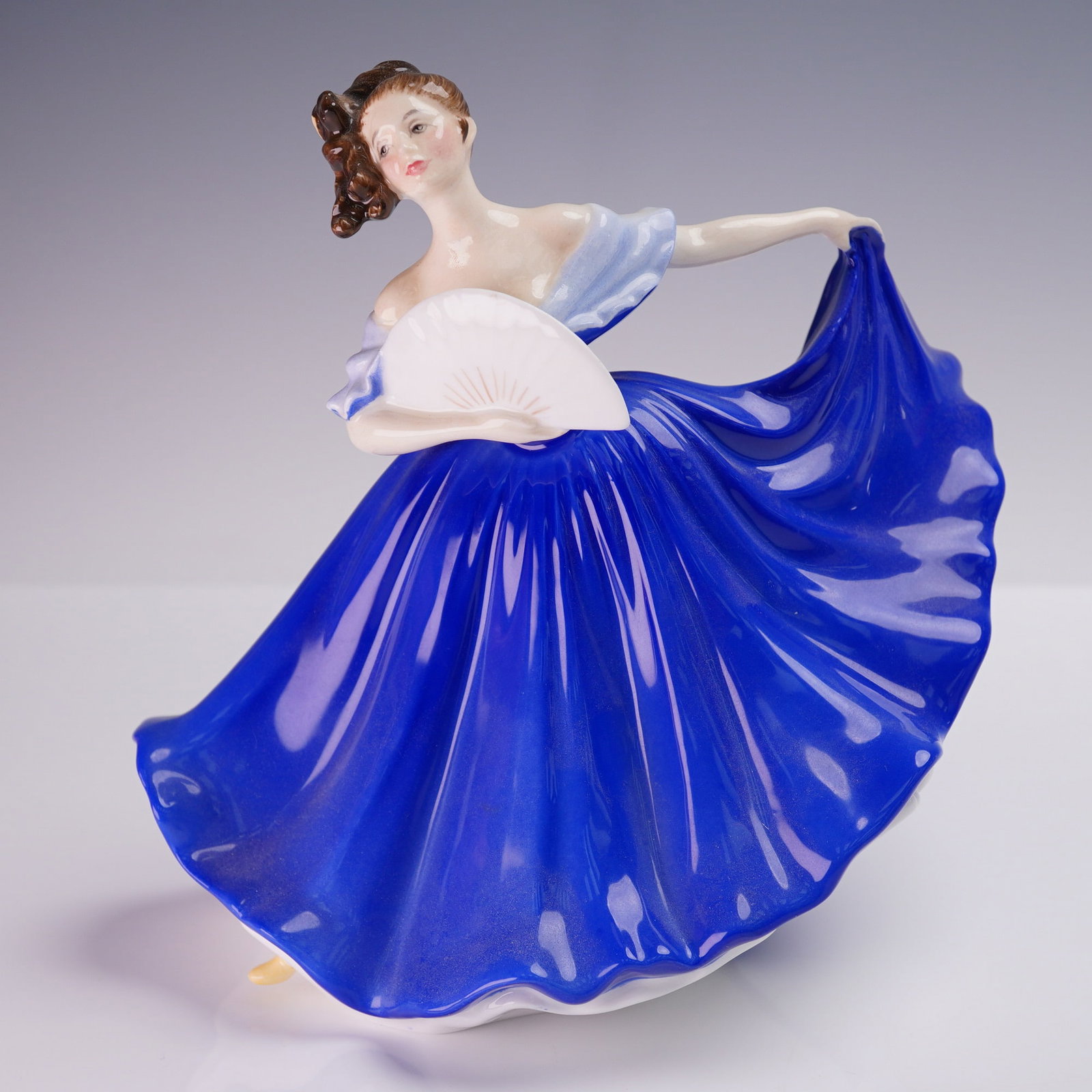 Royal Doulton Figurine, Elaine HN2791: Charming Royal Doulton figurine titled Elaine, HN2791, modeled by Peggy Davies and hand decorated in England. This elegant piece features a young woman in a sweeping cobalt blue gown with off-the-shou