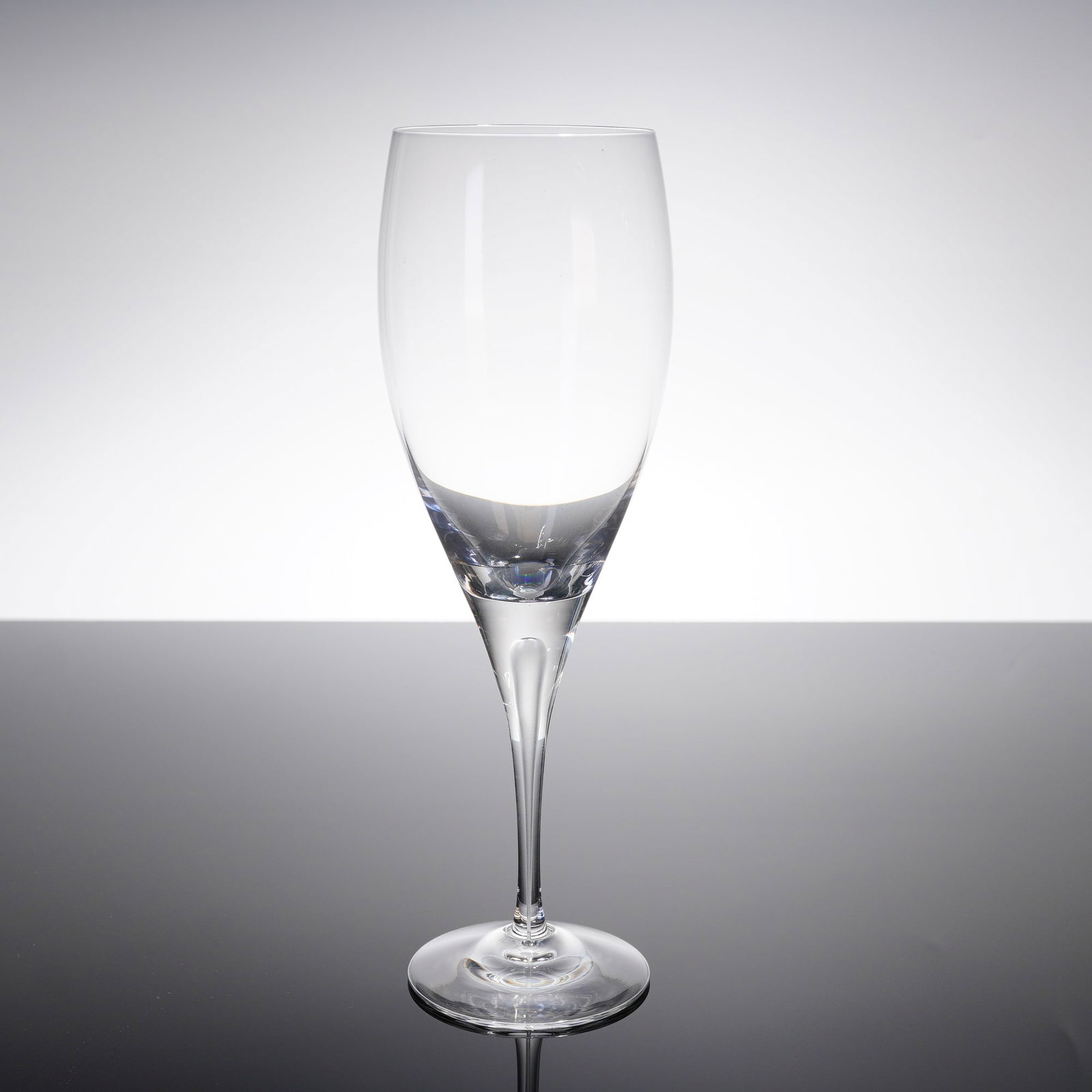 Orrefors Intermezzo Crystal Champagne Flute with Original Box: A single Orrefors Intermezzo crystal champagne ?ute, accompanied by its original black retail box. The ?ute features a modern, minimalist design characterized by a tapered, tulip-shaped bowl, a long,