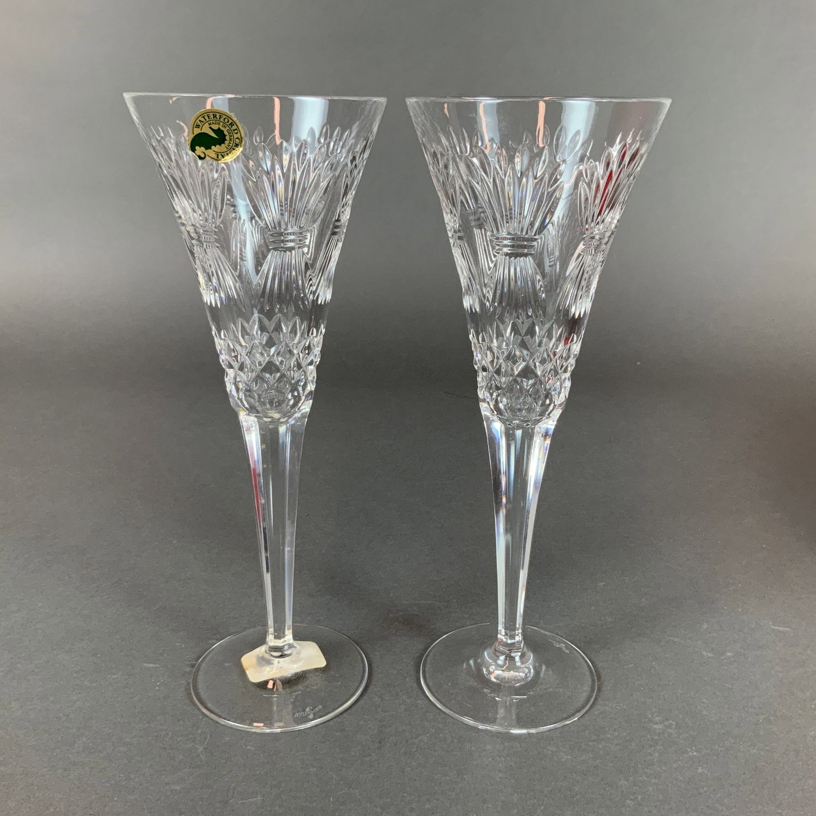 Pair of Waterford Crystal Millennium Prosperity Toasting Champagne Flutes: This pair of toasting flutes is produced by Waterford in the Prosperity pattern, which is part of the Millennium Series. The items are constructed from heavy lead crystal and feature a conical bowl de