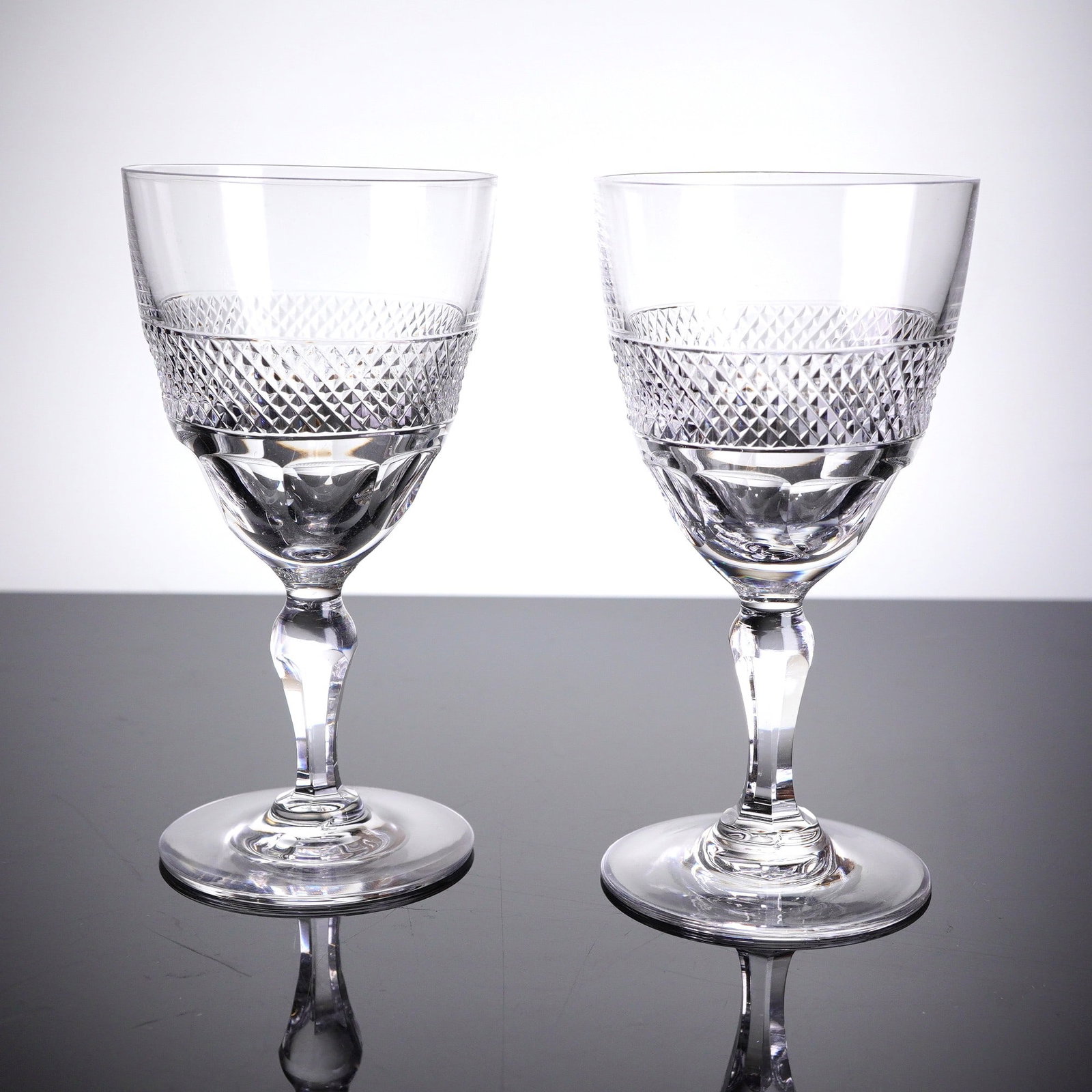 A Pair of Orrefors Rio Patern Cut Sherry Glasses: A pair of clear cut crystal goblets, identi??ed through market consensus as the Rio patern designed by Edward Hald for Orrefors. Each goblet features a deep, clear bowl with a plain, smooth upper rim