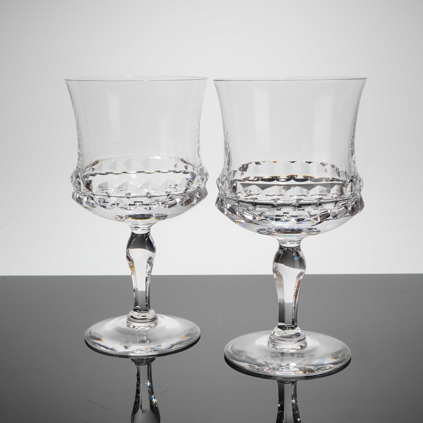 A Pair of Orrefors Silvia Crystal Claret Wine Glasses: A pair of stemmed crystal glasses in the Silvia patern, designed by Ingeborg Lundin for Orrefors. These items are crafted from clear, colorless lead crystal. Each glass features a wide, slightly ?ared