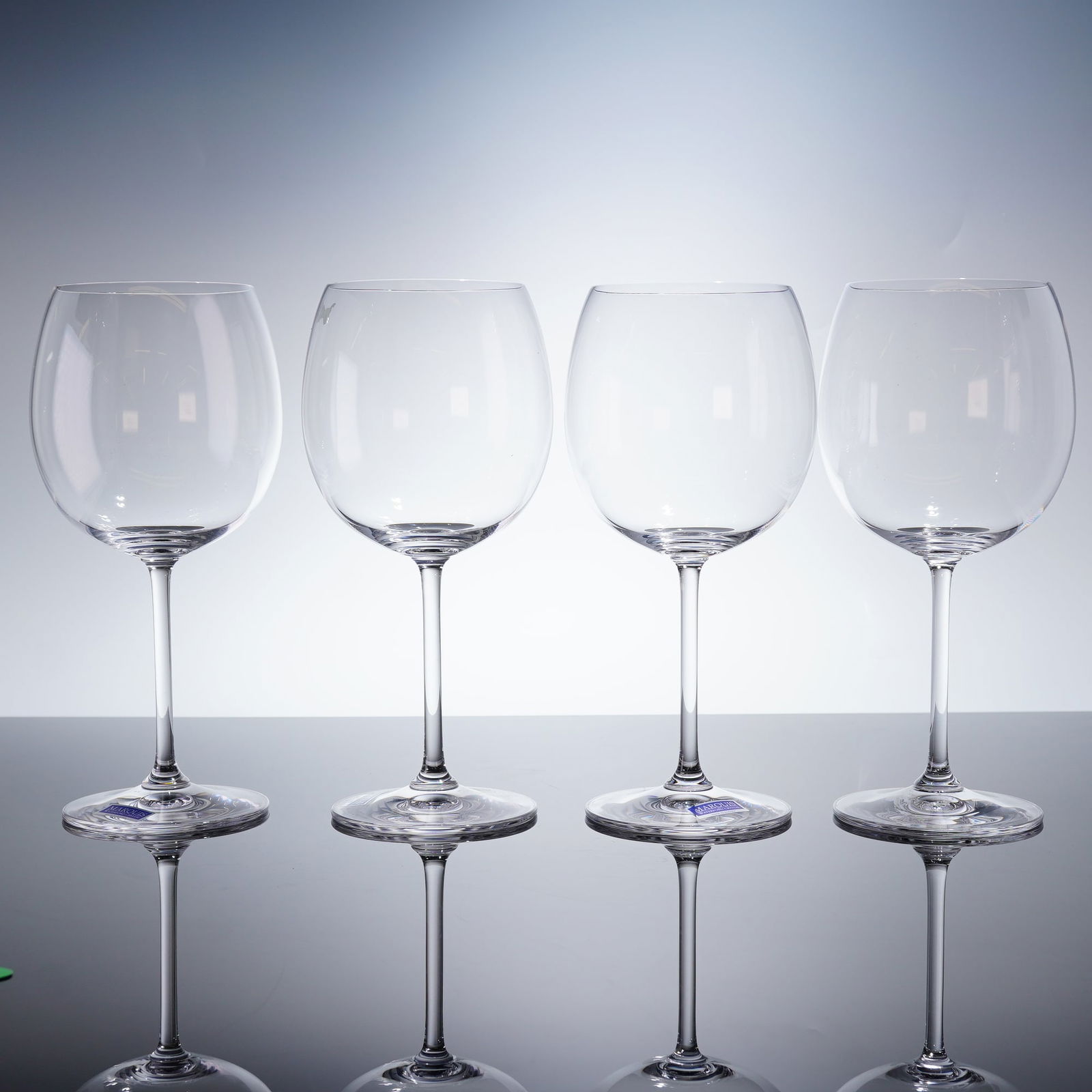 Set of 4 Marquis by Waterford Vintage Tasting Wine Glasses: The set consists of four clear crystal glasses featuring a modern, spherical or balloon-style bowl suitable for light red wines. The glasses are presented with their original blue presentation box, wh