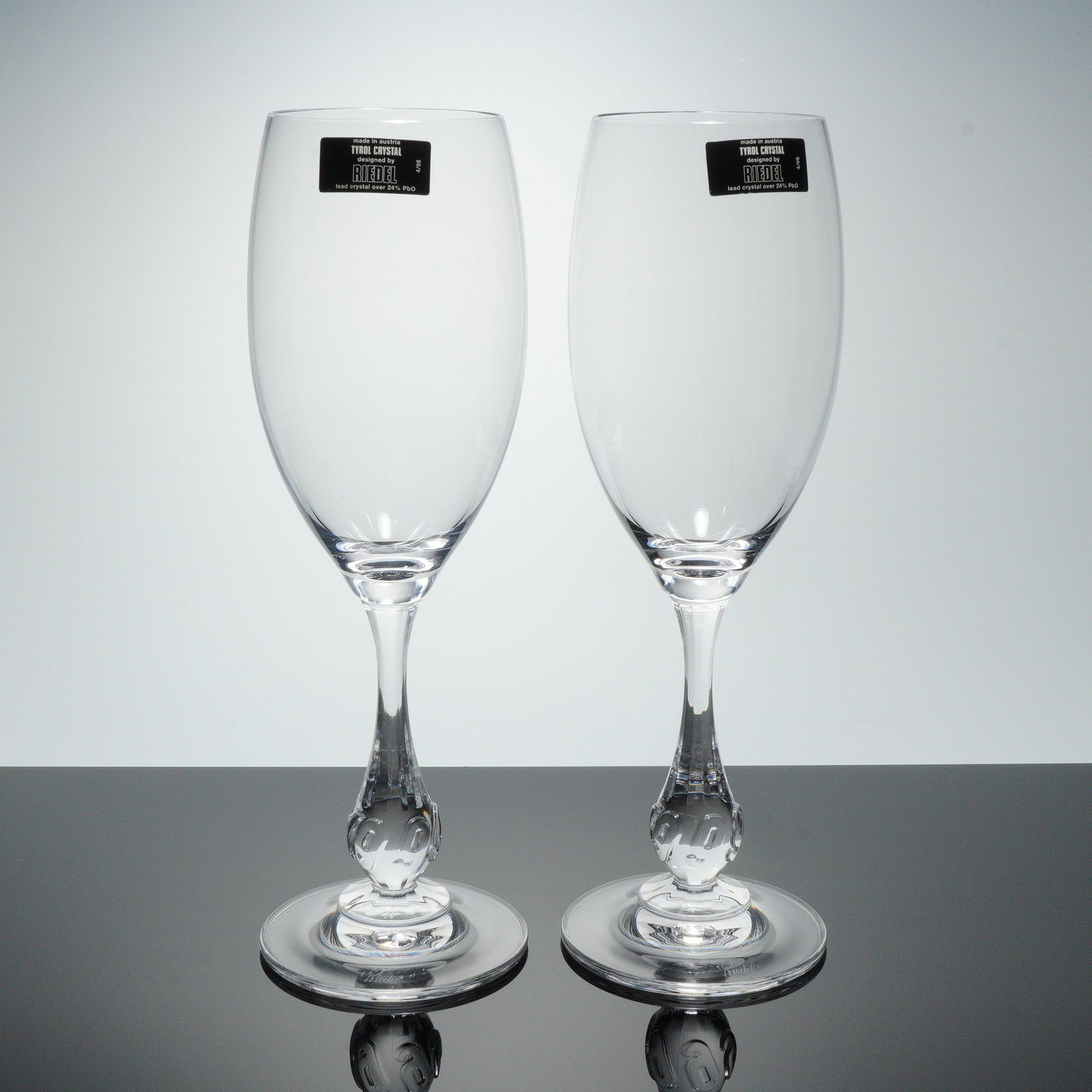 2pc Riedel Tyrol Crystal Toasting Glasses, Pre Millennium: Duo of Tyrol Crystal toasting glasses made in Austria, each crafted in lead crystal with over 24 percent PbO and marked with the original Tyrol Crystal Riedel label, featuring clear bowls above sculpt