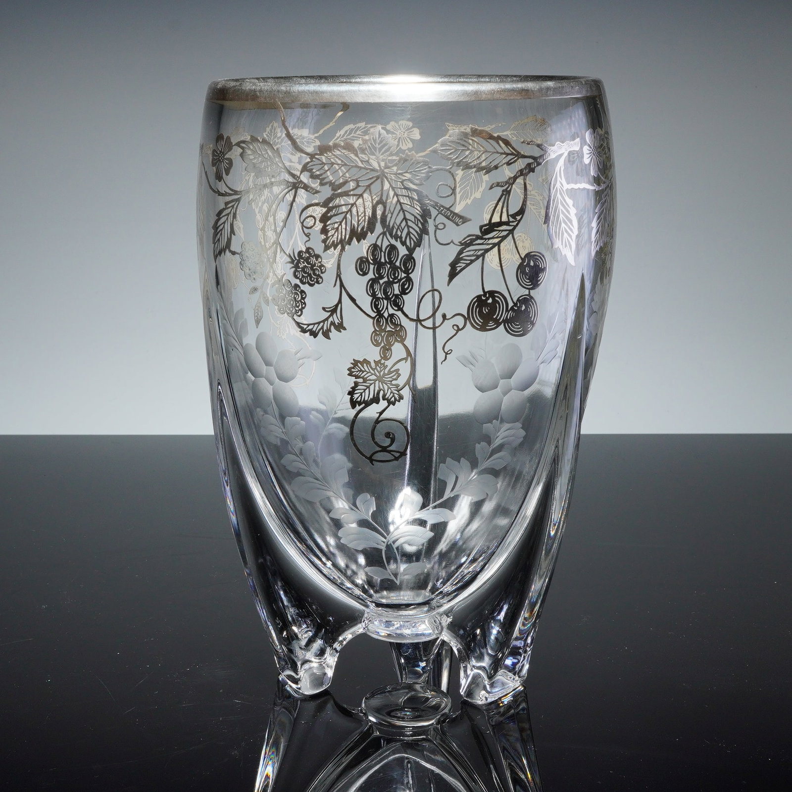 Art Deco Silver Overlay Vase/Wine/Champagne/Cooler: This Art Deco glass vessel features a clear body supported by three integrated tapered feet. The exterior is decorated with acid-etched botanical motifs and a sterling silver overlay depicting fruits