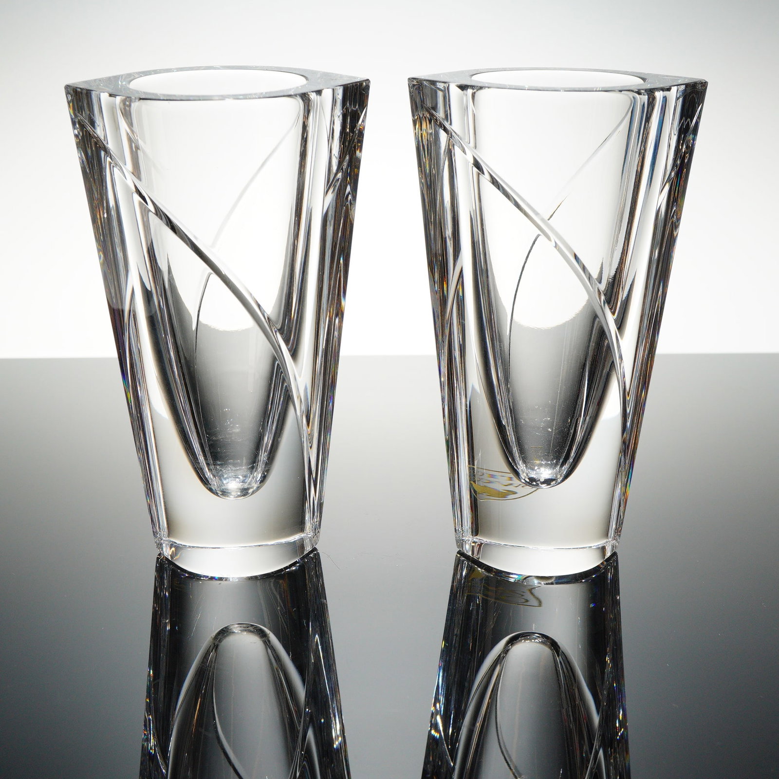 Pair of Orrefors Crystal Vases, Marin Swirl: Set includes two tall Marin Swirl vases. The vessels are crafted from heavy, clear, refractive lead crystal, featuring a contemporary modernist style. Each vase has a substantial, tapering polygonal f