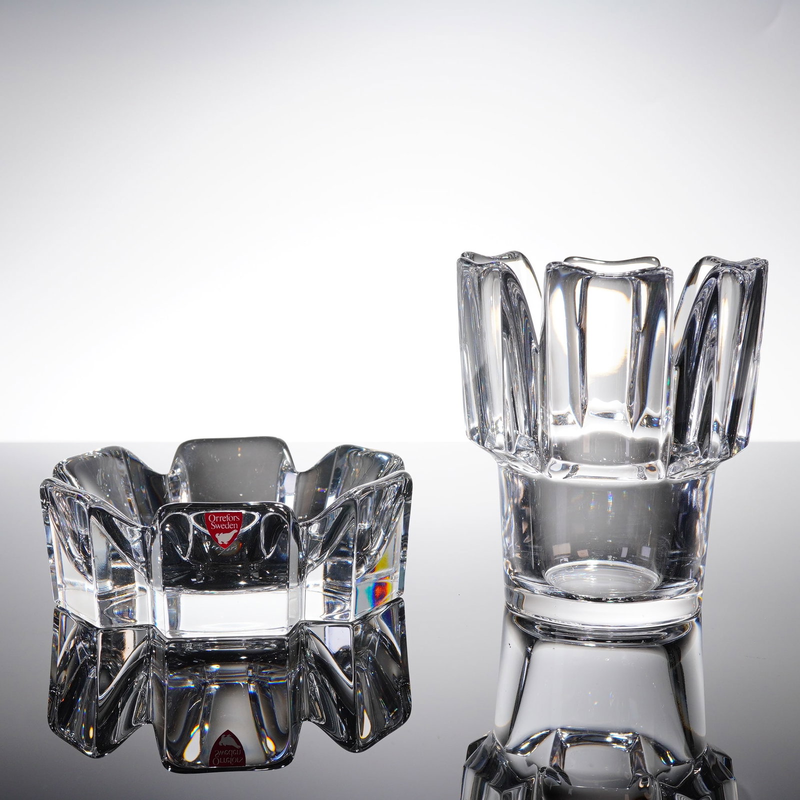 A Pair of Orrefors Swedish Crystal Dish and Vase: A pair of Swedish modernist crystal glass vessels by Orrefors, comprising two items. The ??rst item is a squat, geometric dish featuring heavy faceting and thick walls, consistent with the Orrefors Co