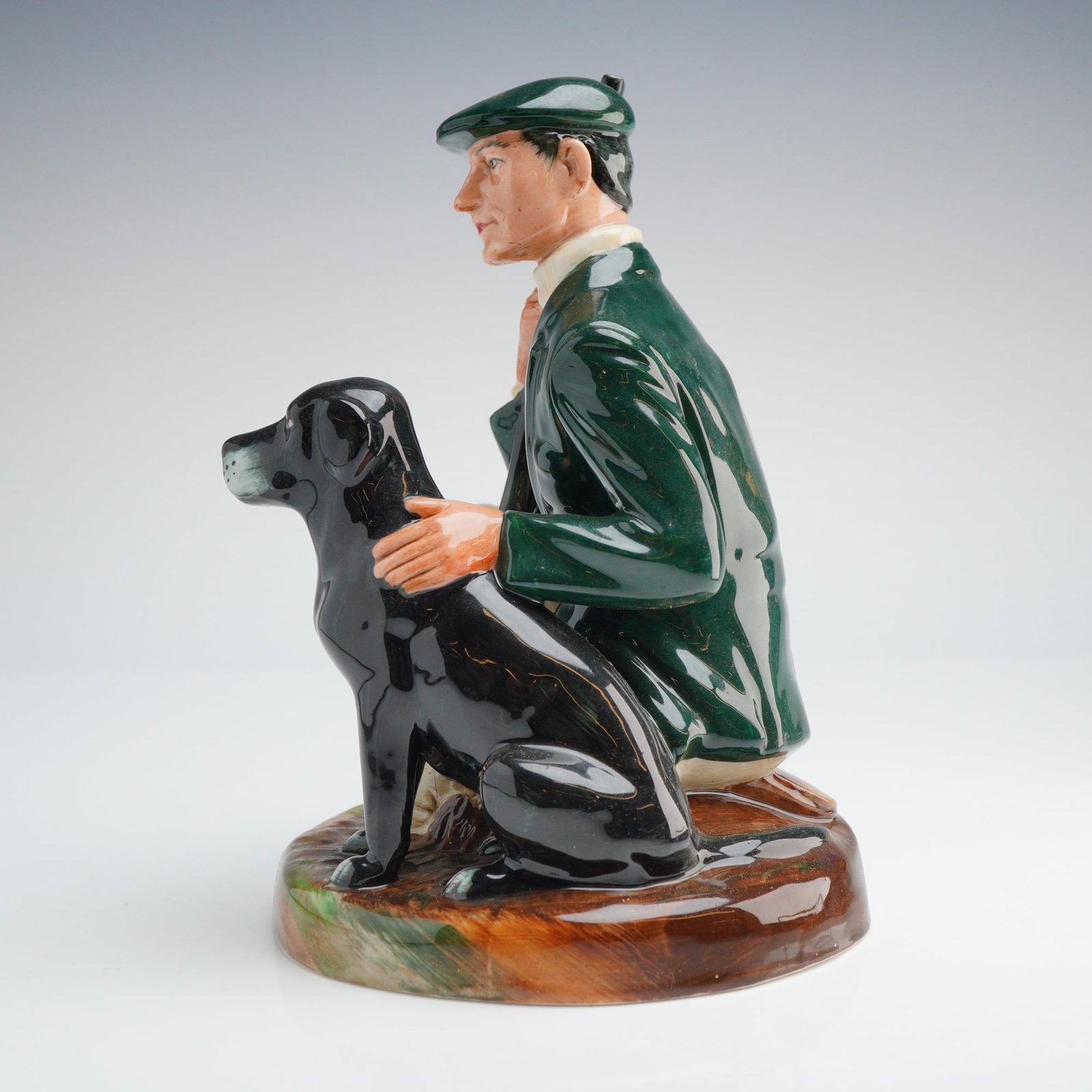 Royal Doulton Figurine Gamekeeper HN2879: Royal Doulton ceramic figurine titled The Gamekeeper, model number HN 2879. Modeled by Eric Griffiths and hand-decorated. The figure depicts a man in a dark green jacket, matching flat cap, and tan br