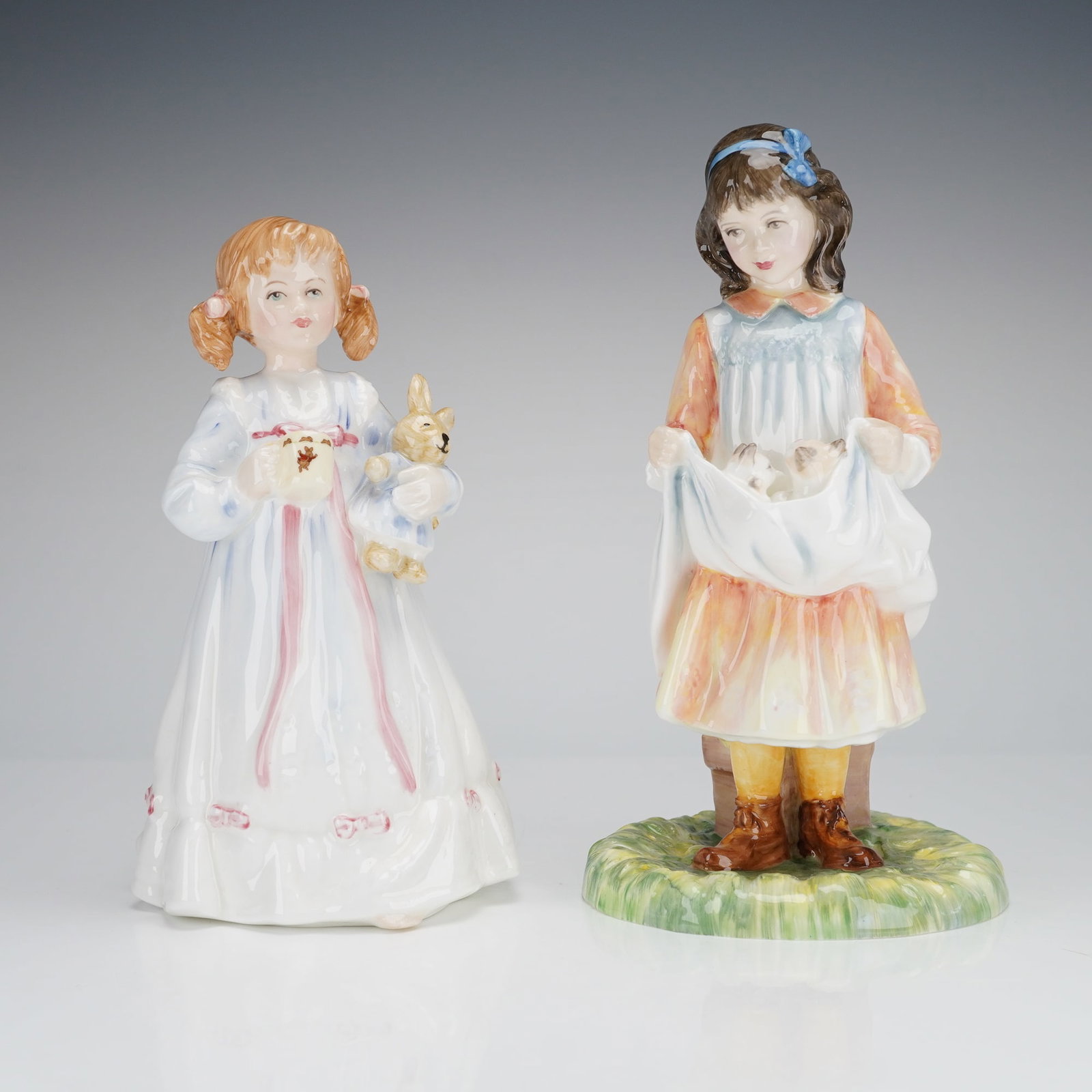 2pc Royal Doulton Figurines Bunny's Bedtime and Maid of Innocence: The first figure, titled Bunny's Bedtime (HN 3370), is marked as a Limited Edition 6/400 RDICC and shows a girl with pigtails in a long white nightgown holding a stuffed rabbit and a small bowl. The s