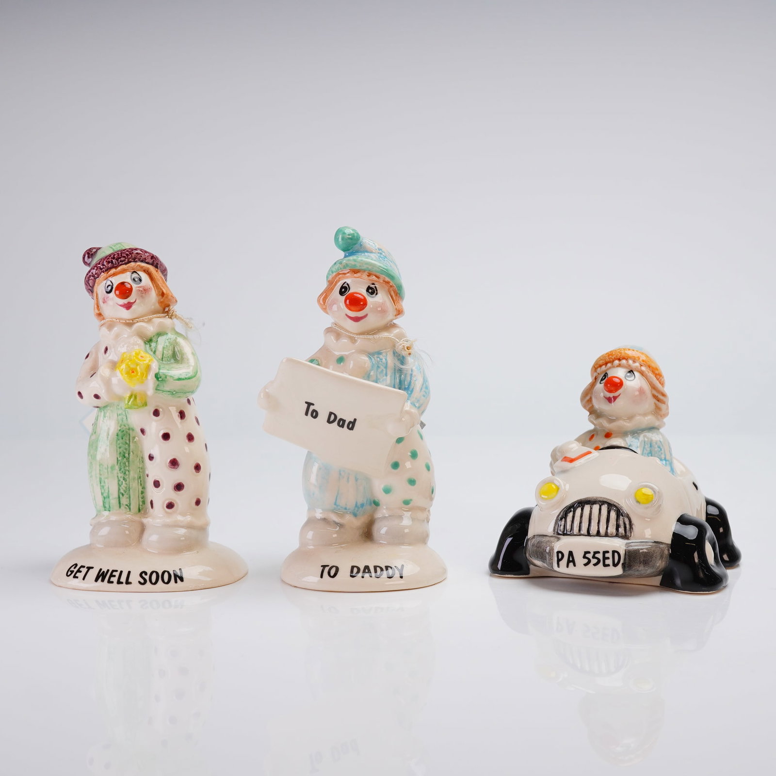 3pc Beswick Little Lovables Clown Figurines: A collection of three glazed ceramic figurines from the Beswick Little Lovables series, each featuring a hand-painted clown character. The group includes a standing clown in a patterned costume holdin