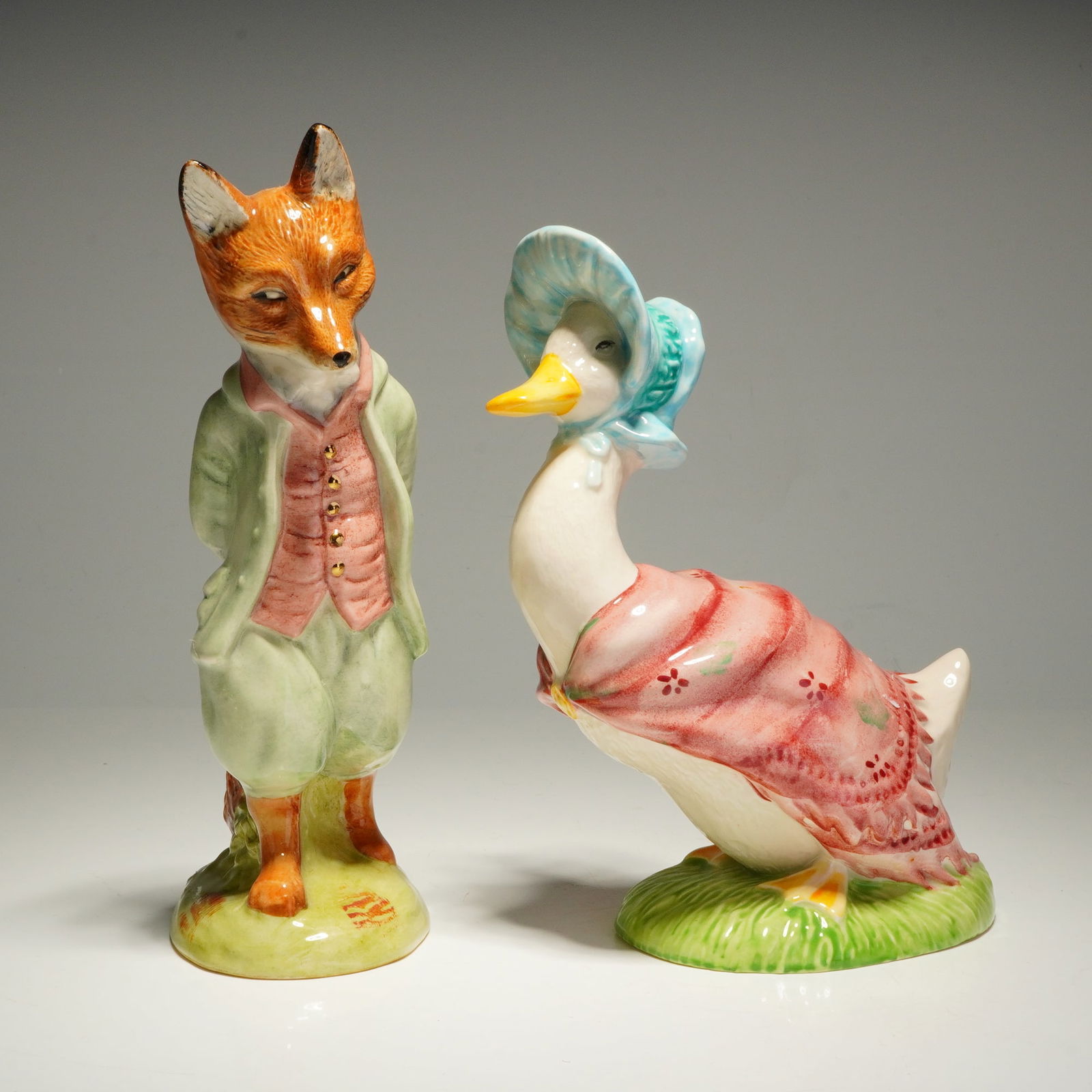 2pc Beswick Beatrix Potter Figurines Foxy Whiskered Jemima Puddle Duck: Two Beswick Beatrix Potter porcelain figurines comprising Foxy Whiskered Gentleman and Jemima Puddle-Duck. These hand-painted figures feature a glossy glaze. The Foxy Whiskered Gentleman is depicted i