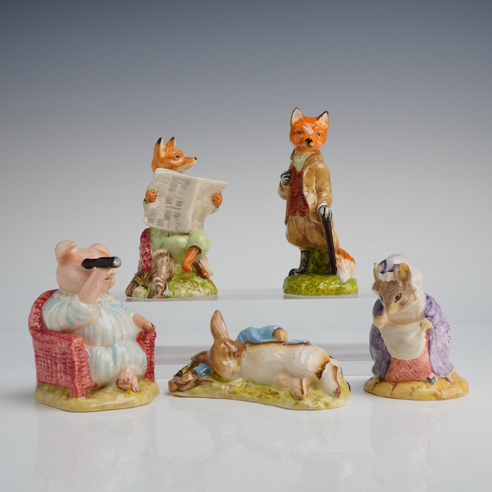 Collection of Five Royal Albert Beatrix Potter Figurines: A collection of five glazed ceramic figurines manufactured by Royal Albert, depicting anthropomorphic characters from the Beatrix Potter stories. The pieces are individually posed on naturalistic base