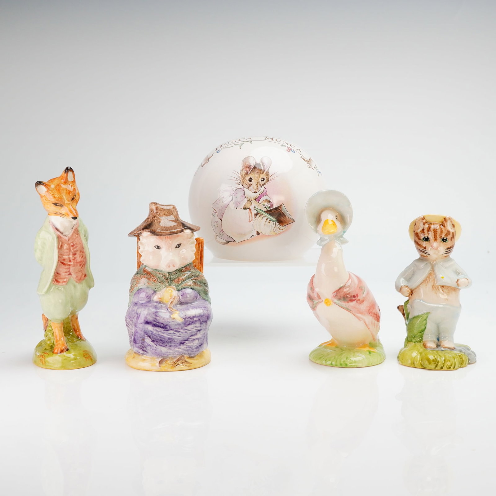 5pc Beatrix Potter Figurines from Beswick Royal Albert: A collection of five ceramic items featuring characters from the world of Beatrix Potter, comprising four hand-painted glazed porcelain figurines by Beswick and one spherical coin bank by Royal Albert