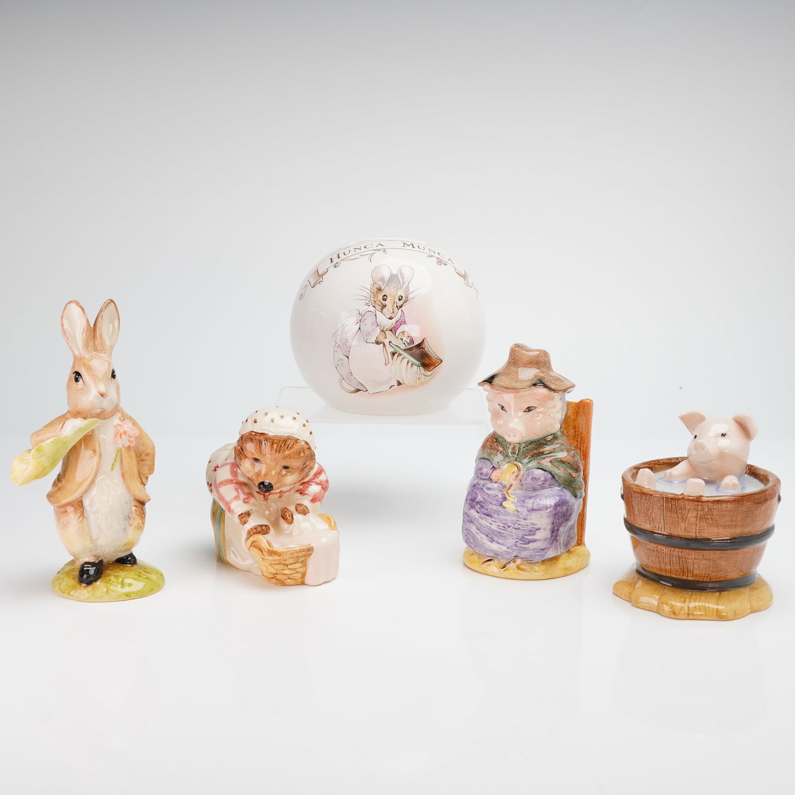 5pc Beatrix Potter Set of Beswick Figurines and Royal Doulton Bank: This 5pc Beatrix Potter set consists of four polychrome glazed ceramic figurines produced by the Beswick pottery works under the ownership of Royal Doulton and one ceramic bank by Royal Doulton. The f