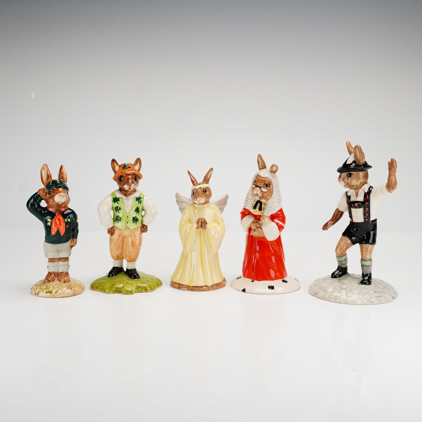 5pc Royal Doulton Bunnykins Figurines: A set of five Royal Doulton Bunnykins ceramic figurines. This collection features anthropomorphic rabbits in various thematic roles, including a scout titled Be Prepared, an Irishman in a shamrock-pat