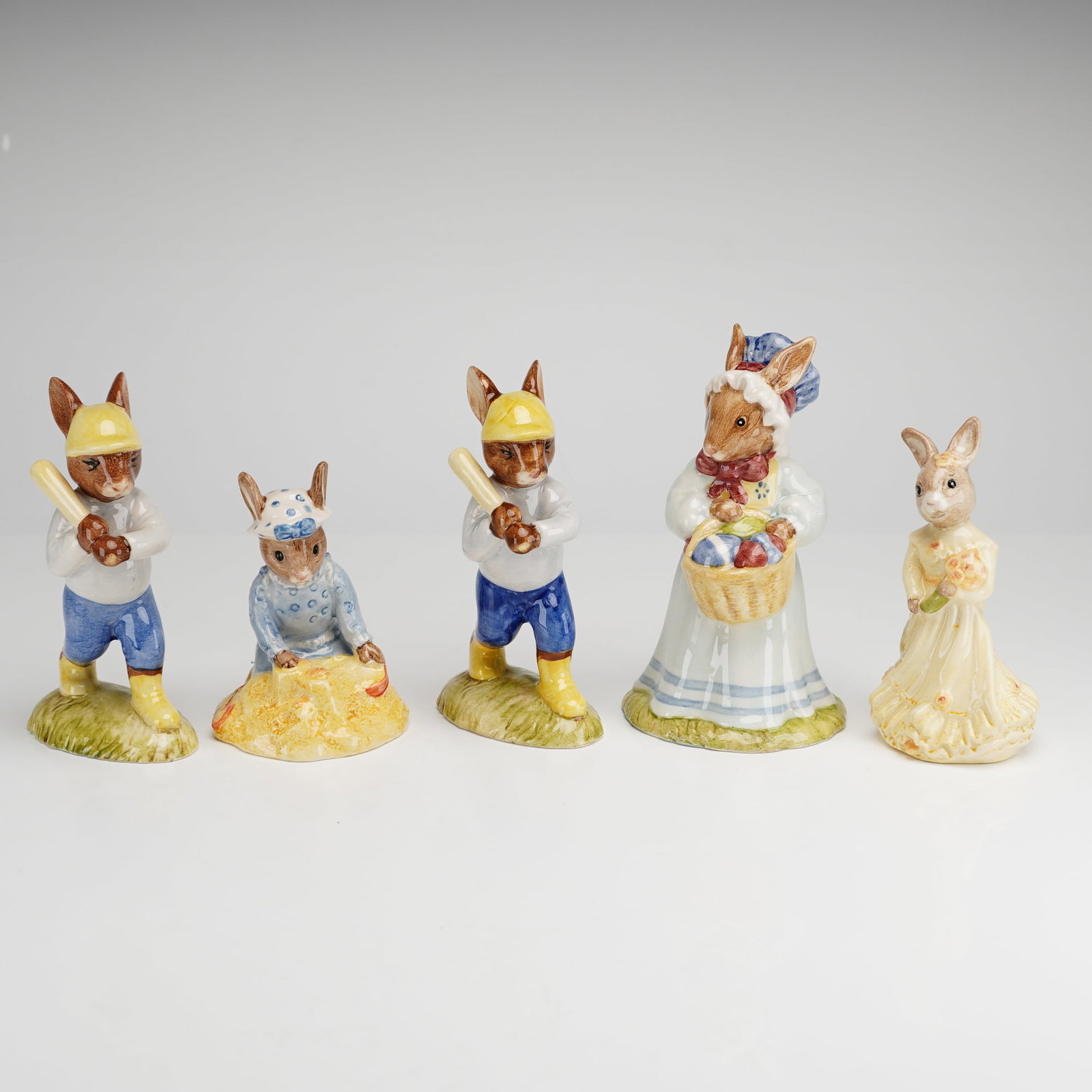 5pc Royal Doulton Bunnykins Figurines: A group of five hand-painted porcelain figurines from the Royal Doulton Bunnykins series, manufactured in England. This collection includes two Home Run Bunnykins DB43 depicting baseball players weari