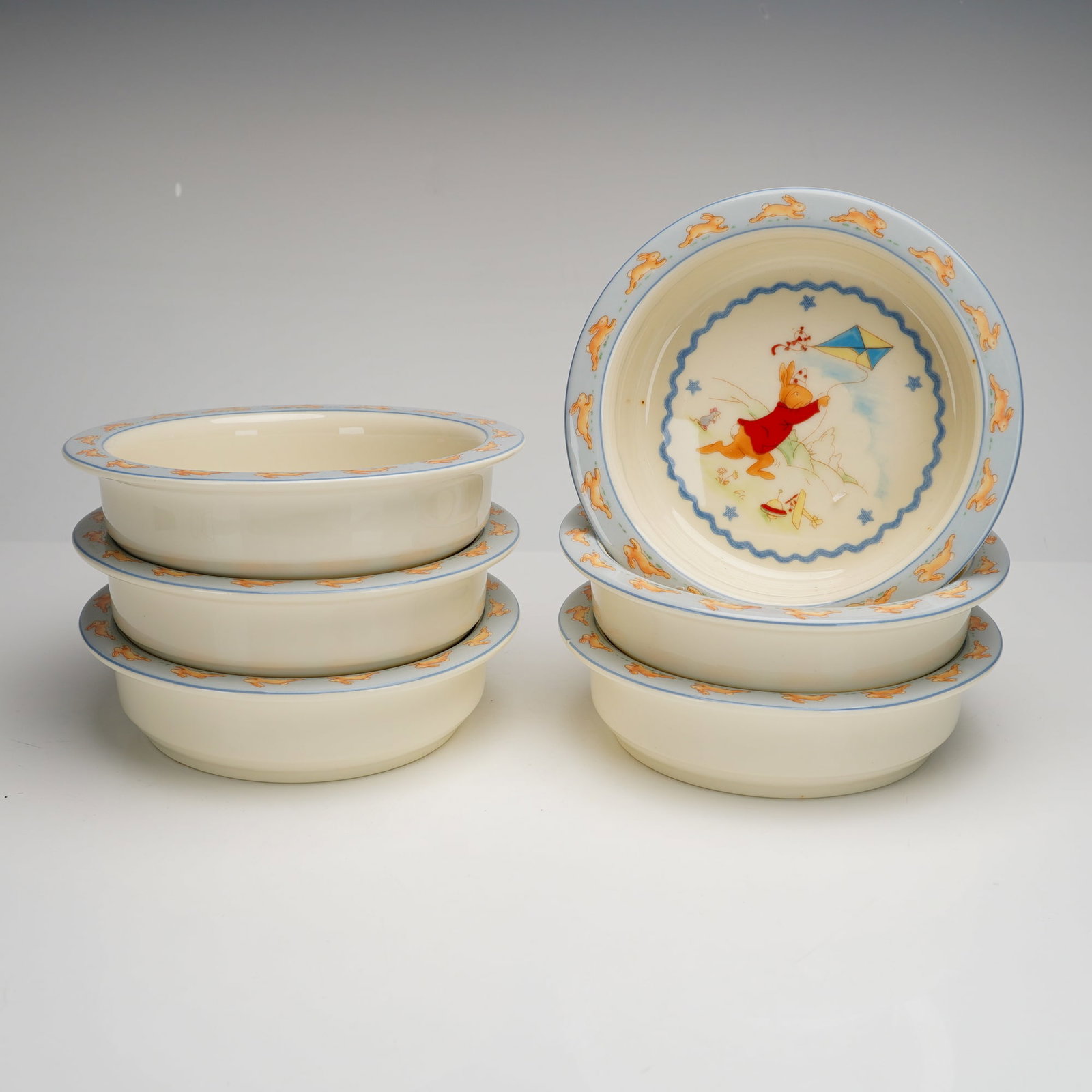 6pc Royal Doulton Bunnykins Shining Stars Bowl Set, H.5318: A 6pc Royal Doulton Bunnykins bowl set in the Shining Stars pattern H.5318. These nursery bowls are constructed from fine bone china. Each bowl features a central illustration of a rabbit wearing a re