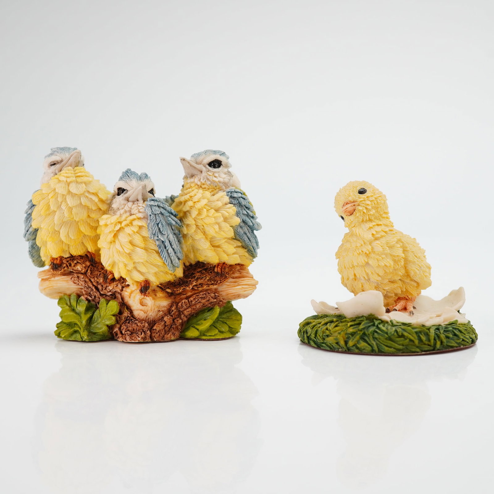 2pc Country Artists Resin Bird Figurines: Two Country Artists resin figurines. The first figurine depicts three fledglings huddled on a textured branch, with the reverse marked Langford and CA copyright 1992. The second figurine features a si