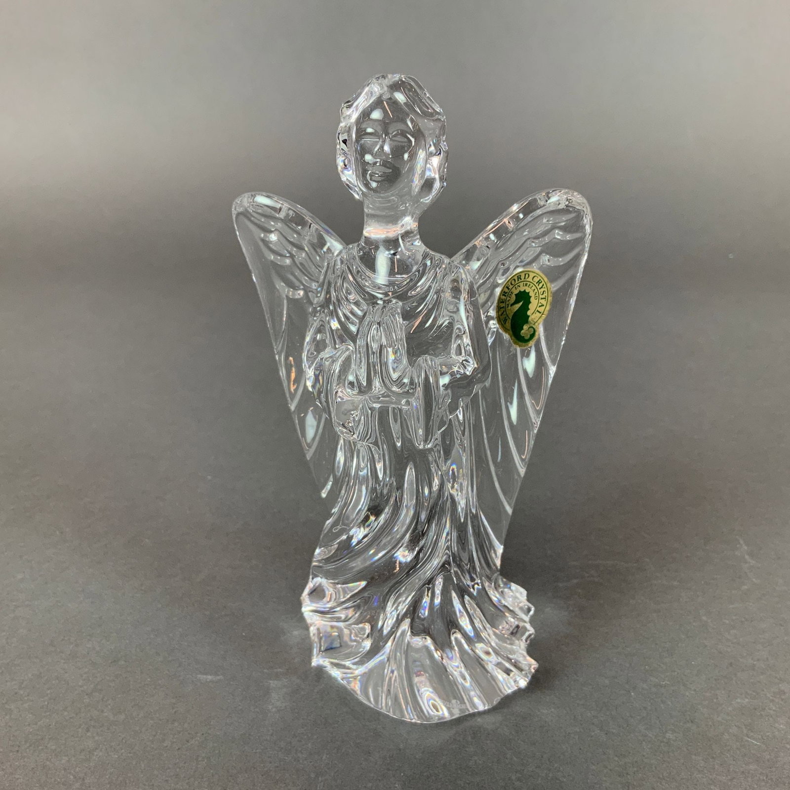 Waterford Crystal Guardian Angel Figurine: This Waterford Crystal lead glass figurine is identified as the Guardian Angel sculpture. The clear crystal piece depicts a praying angel with outspread wings and hands clasped in front. The sculpture