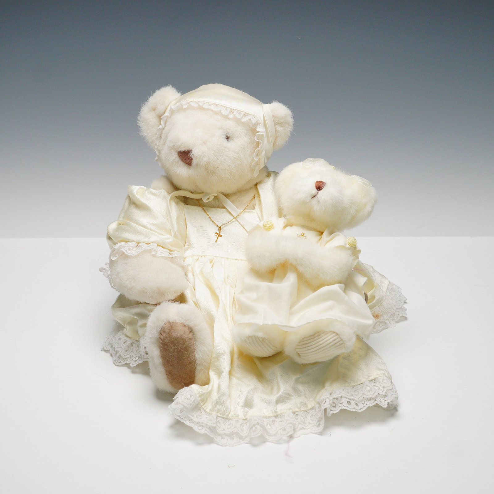 Pair of Vintage Vermont Teddy Bear Co. Bears, Calista: A set of collectible bears dressed in ivory satin and lace outfits with gold cross necklaces. One bear, named "Calista," is a limited edition. Wearing a satin bonnet and dress with lace trim. The comp