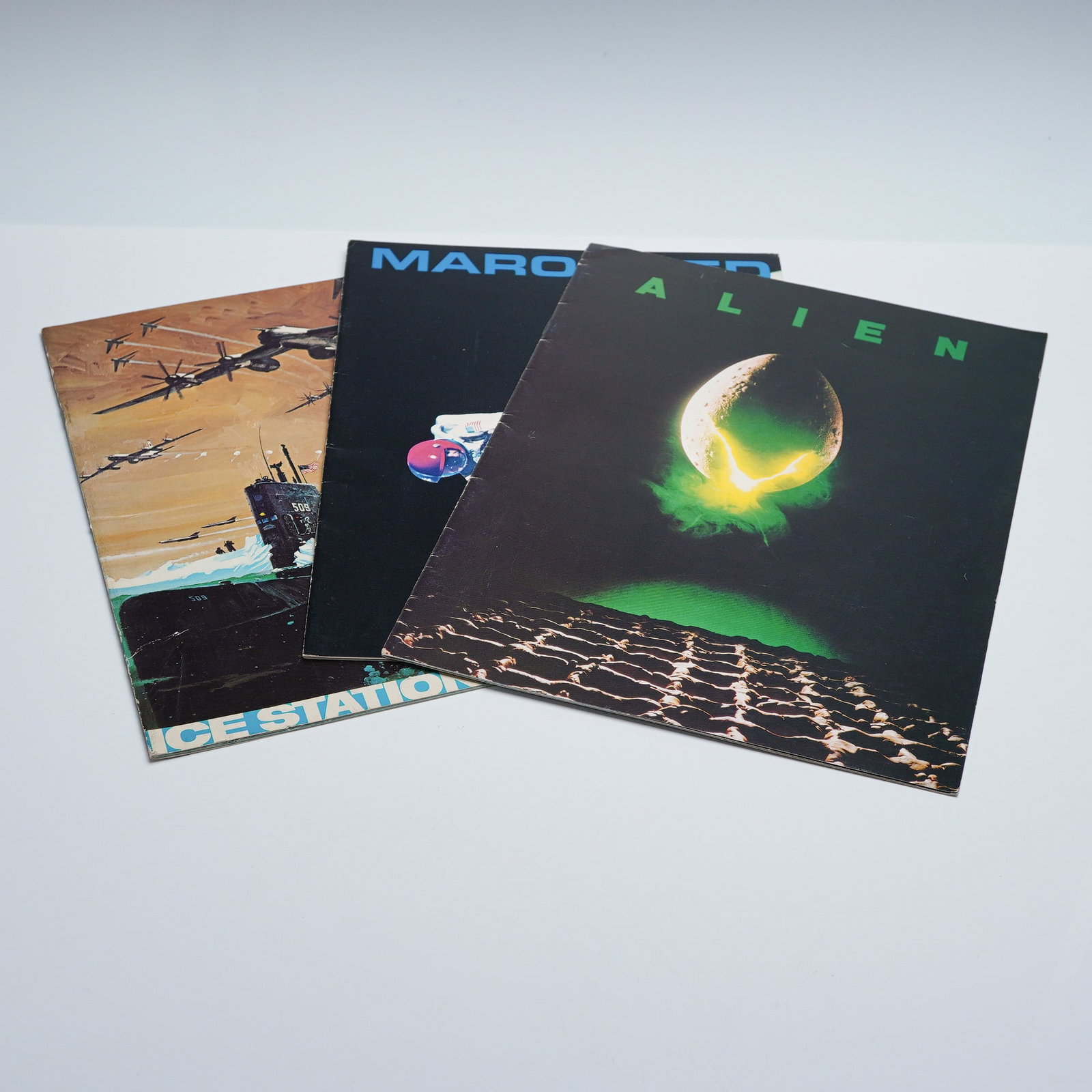 3pc ALIEN and other Movie Promotional Material: Lot of 3 vintage movie promotional booklets featuring titles from science fiction and action cinema. Includes Alien with its iconic egg cover, Marooned featuring a dramatic spacewalk scene, and Ice St