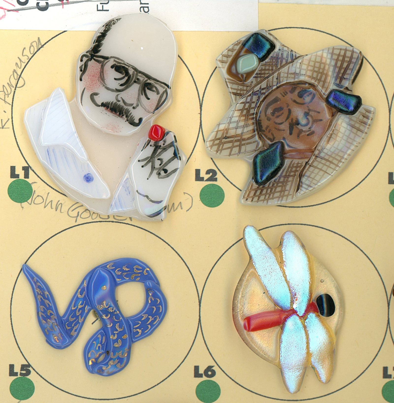 A PARTIAL CARD OF DIVISION THREE GLASS BUTTONS: 4 Large 20th/21st century colorful lampwork examples. This fun lot from the eclectic collection of Nikki Deal includes a variety of subject matter in realistic shapes and colorful lampwork designs. No