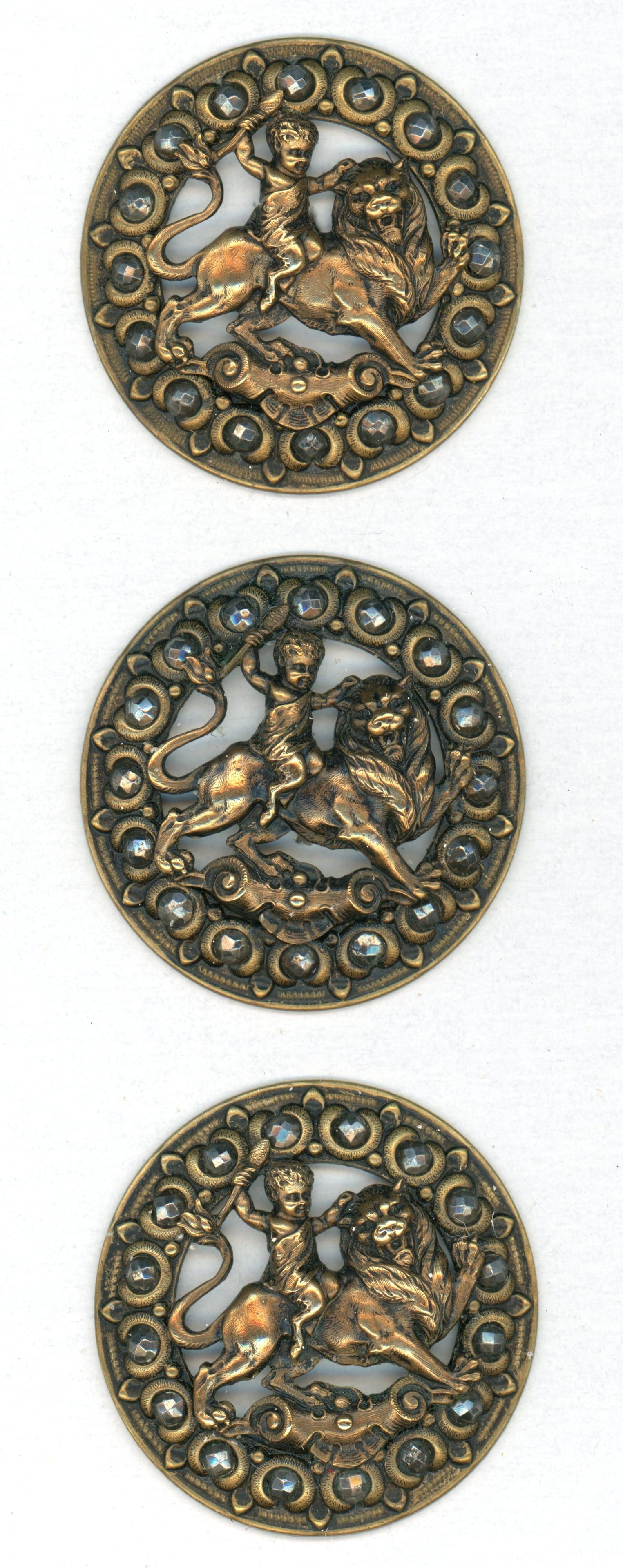 A SMALL CARD OF DIVISION ONE PICTORIAL MATCHING BUTTONS: 3 Large 19th century detailed pierced examples. This small card boasts 3 buttons in great detail depicting a Cherub riding a lion and bordered with cut steels. These are really high quality detailed