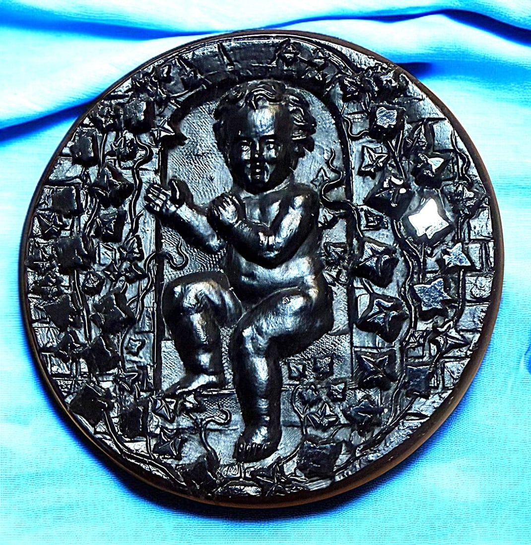 A RARE DIVISION ONE BLACK GLASS PICTORIAL BUTTON: 1 Large 19th century backmarked Cherub and Trellis example. This is a very detailed glossy and matte finish example from the 19th century. These backmarked examples are very few and far between and ar