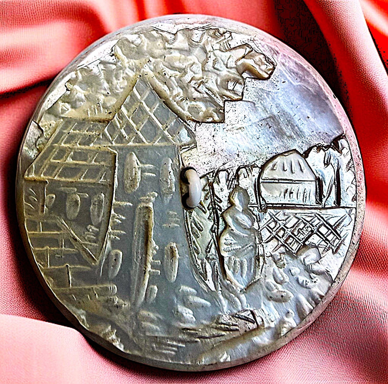 A DIVISION ONE CARVED PEARL SCENE BUTTON: 1 Large-Medium 1 1/4" 19th C. sew thru architectural example. Here is a finely detailed and amazingly carved pearl button depicting a women in an architectural structure scene. DimensionsSM=Less than