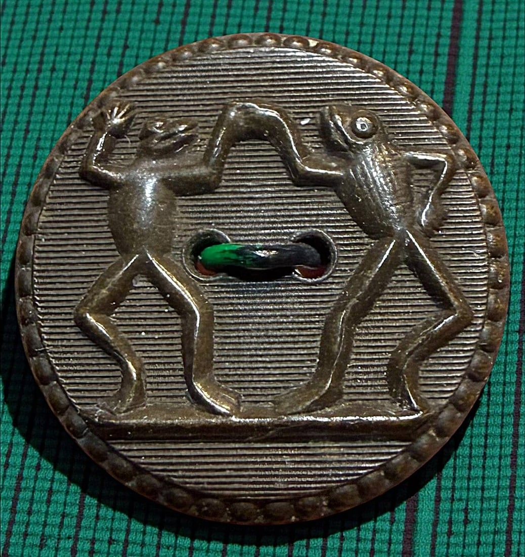 A DIVISION ONE BACKMARKED RUBBER BUTTON: 1 Medium 19th century Dancing Frogs rubber button. This is a very desirable example for button collectors. A greenback Goodyear 1851 example. DimensionsSM=Less than 3/4", Medium=3/4" to 1 1/4". Large=
