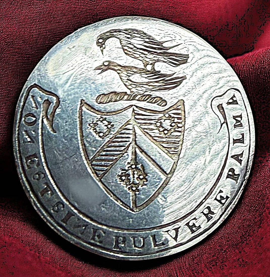 A DIVISION ONE SILVER CREST BUTTON: 1 Small engraved silver 18th century crest button. Here we have a beautifully detailed and engraved with two birds above a torse and above a shield which is subsequently above a half circle verbal say