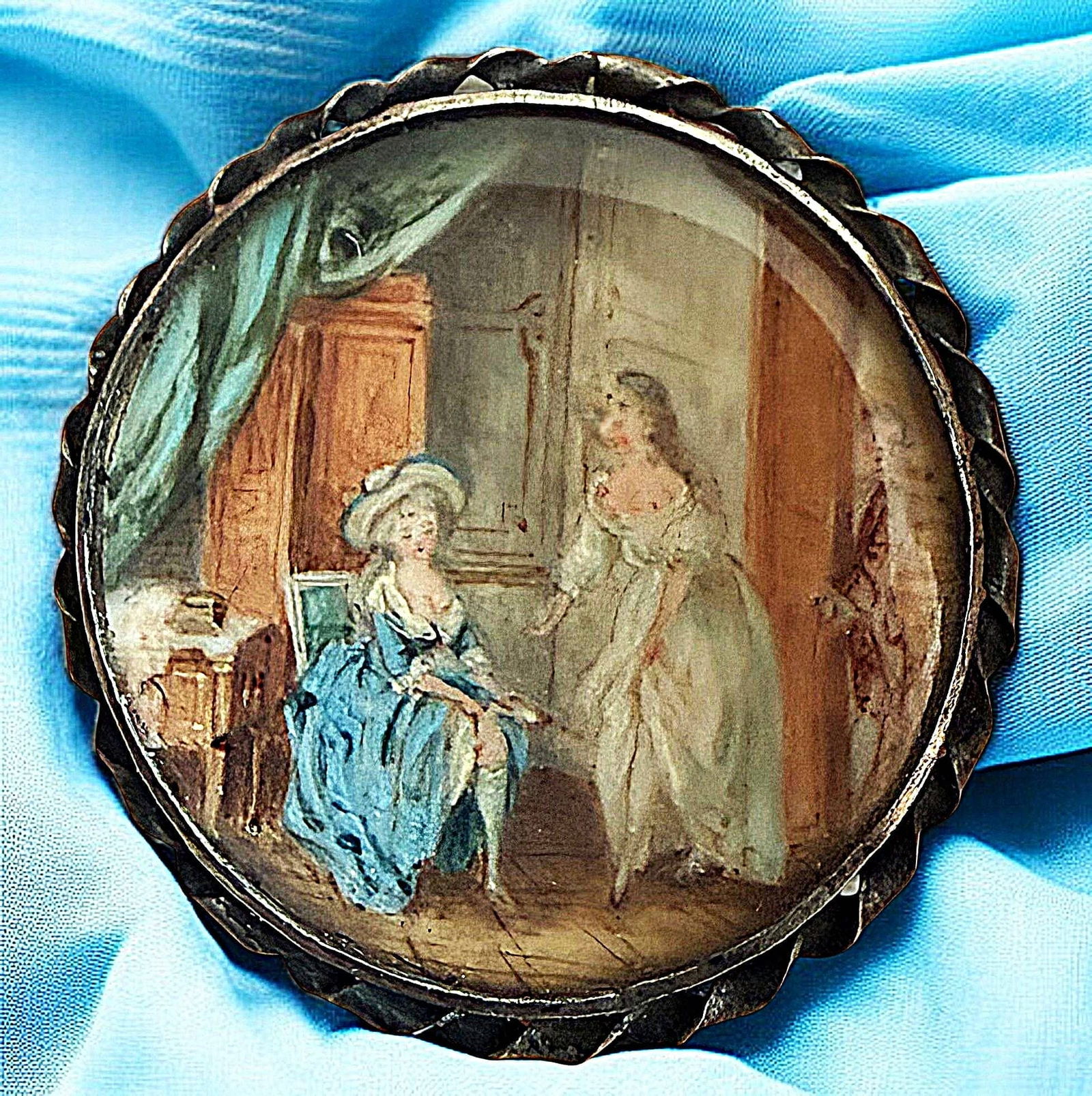 A DIVISION ONE DETAILED SCENE UNDER GLASS BUTTON: 1 Medium size 19th century interior scene hand painted button. The detail in this example is quite exceptional along with the beautiful colors the artist chose to create with. The scene shows an 18th
