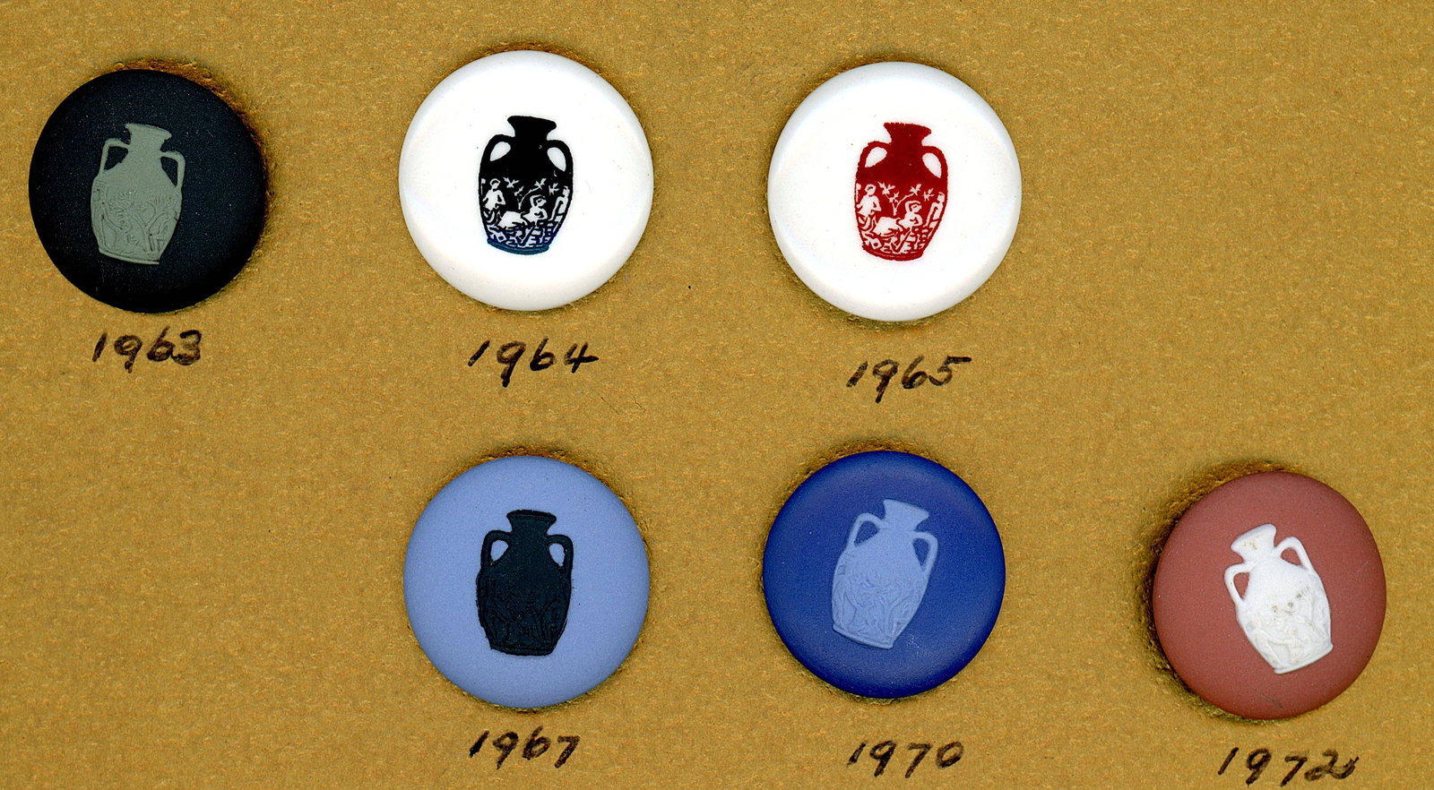 A SELECTION OF DIVISION THREE WEDGWOOD BUTTONS: 6 Medium 20th century Wedgwood seminar favor buttons. Like the button societies, the Wedgewood society gives a favor button each year of their conventions. Every year a different coloration of the sam
