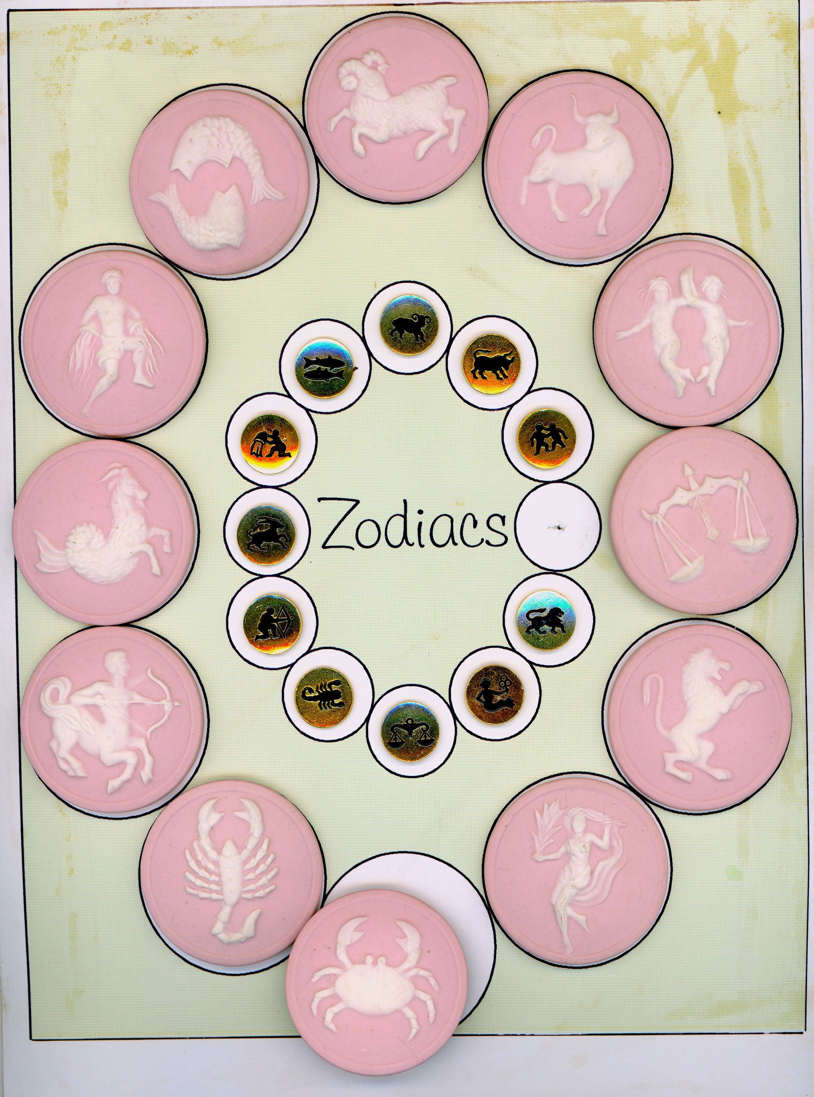 A CARD OF DIVISION THREE STUDIO ARTIST BUTTONS: 23 Small/Ex Large 20th century examples of the Zodiac signs. This card includes a wonderful and less common pink Jasperware set by the late Stella Rzanski. The card also includes a small brass set but