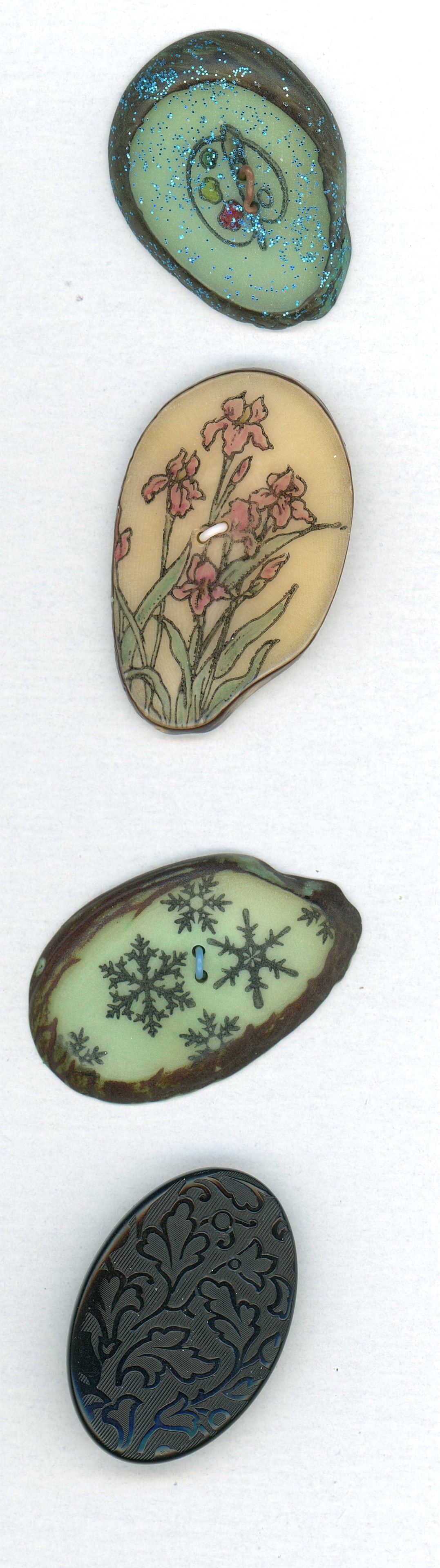 A SMALL CARD OF DIVISION 1 & 3 VEG. IVORY BUTTONS: 4 Large 19th/21st century examples including pictorials. This lot includes one old oval molded floral pattern in dyed black VI along with 3 beautiful examples made and signed by Cathy Mayer of Minneso