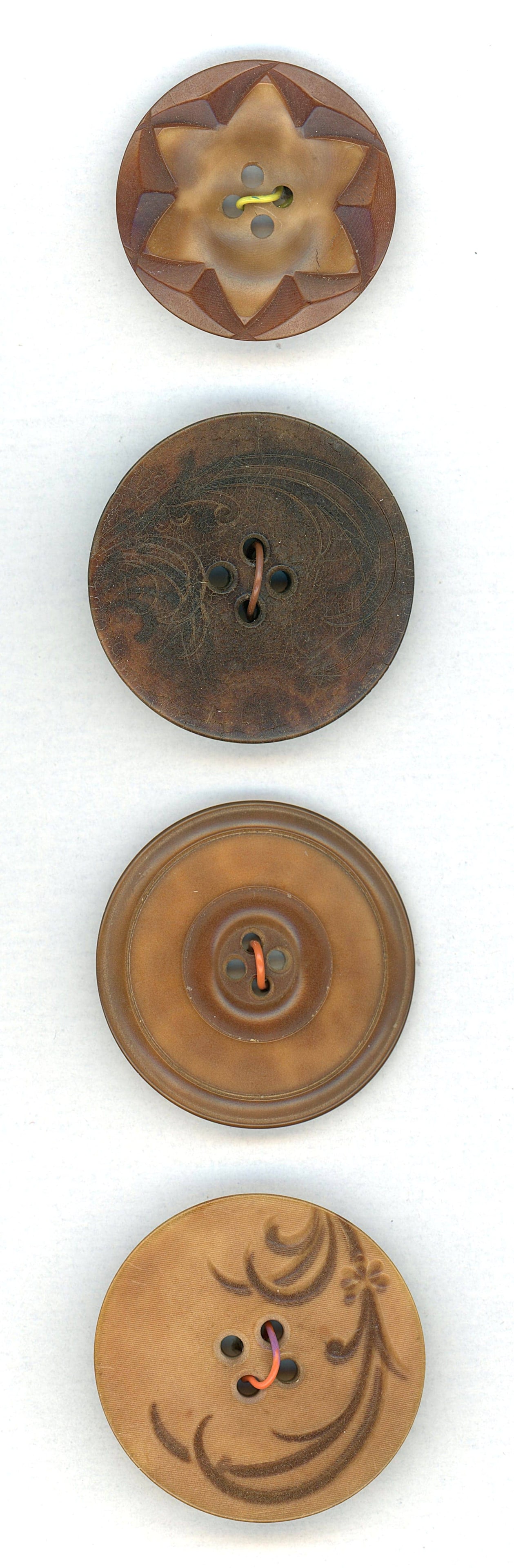 A SMALL CARD OF DIVISION 1 VEG. IVORY BUTTONS: 4 Large 19th century examples including pictorials. This small selection includes two buttons with the same design, one is carved and dyed, and the other is engraved. The lot also includes 2 very