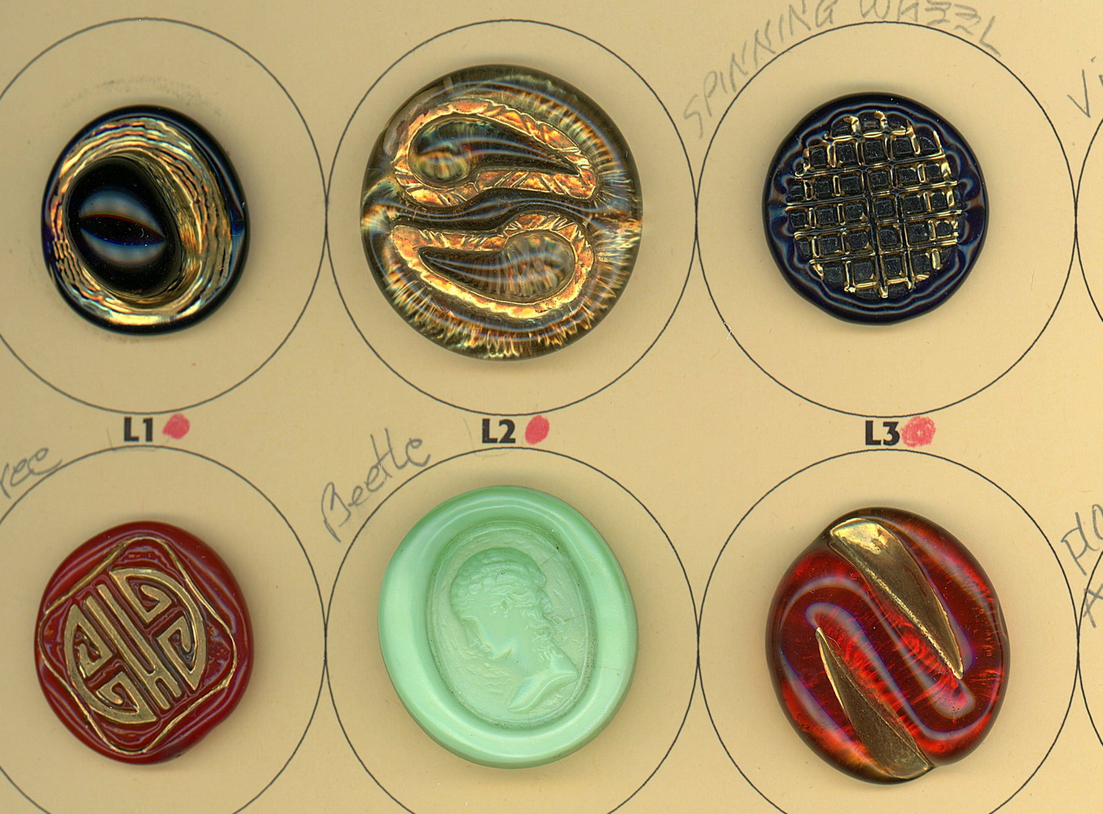 A PARTIAL CARD OF DIVISION THREE GLASS BUTTONS: 6 Medium/Large 1940's English Bimini examples. Here is a nice card of these desirable glass buttons from England in the mid 20th century. The lot includes patterns and pictorial. DimensionsSM=Less tha