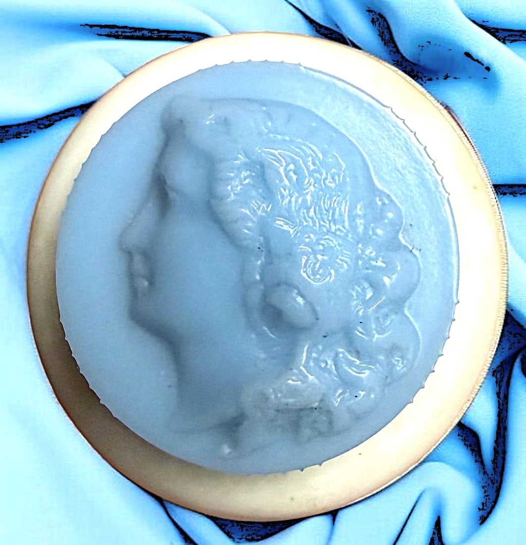 A DIVISON THREE TWO PART COLT BUTTON: 1 Medium 20th C. rouge button from the Colt Manufacturing Co. These Rouge buttons are very desirable among collectors. This example has a blue screw on cap with the typical molded ladies head. Notice
