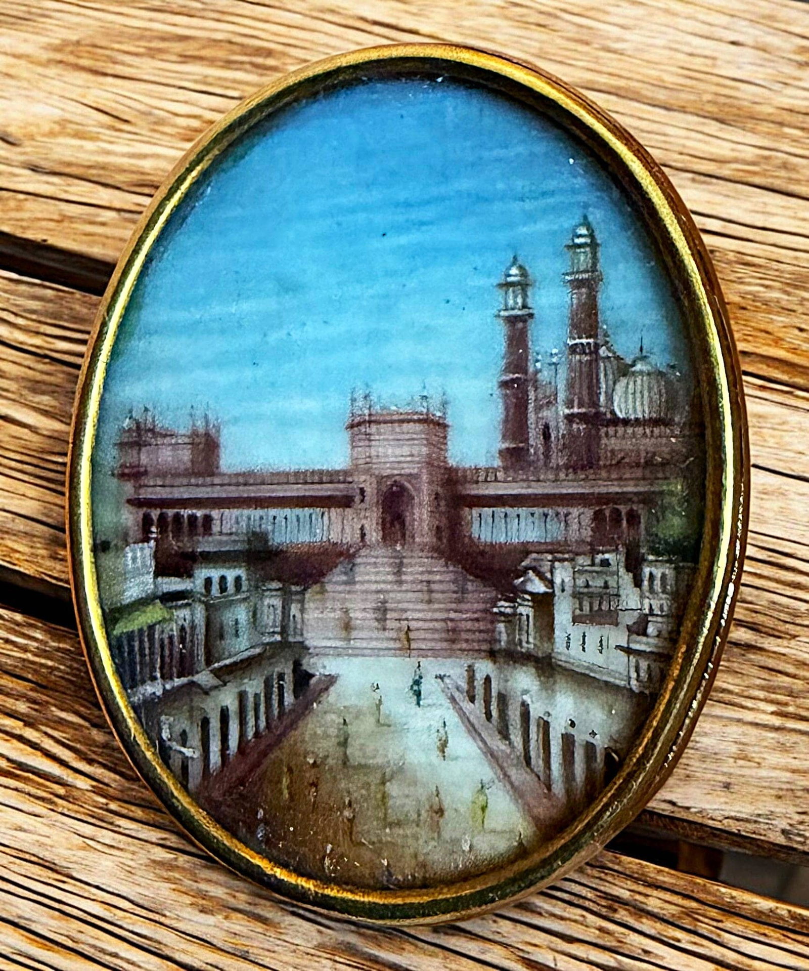 A DIVISION ONE HAND PAINTED SCENE IN GOLD BUTTON: 1 large medium oval 19th century natural material under glass. This is one of three examples in the auction, each depicting a different recognizable architectural structure. Each is hand painted in vi