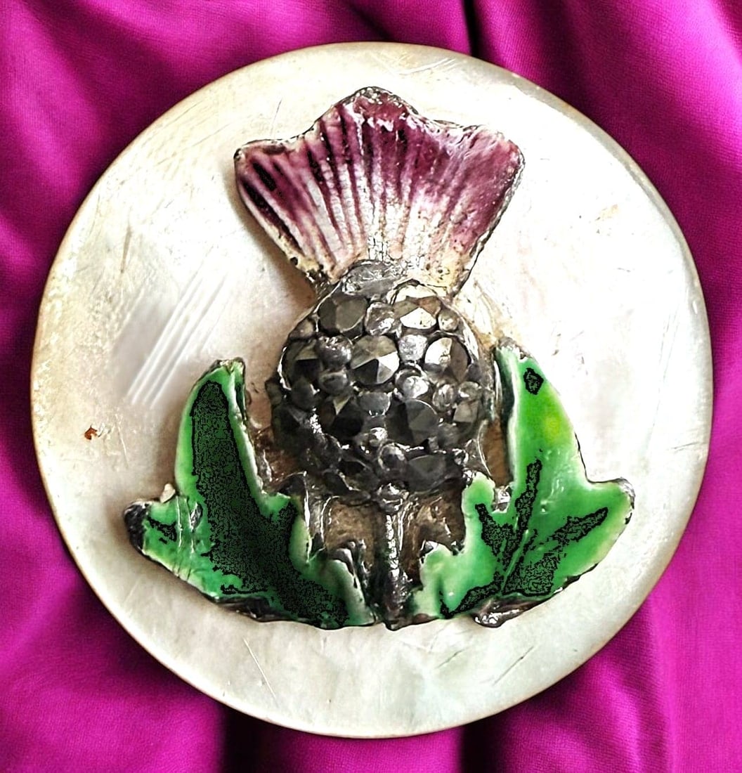 A RARE DIVISION ONE 4 MATERIAL PEARL PICTORIAL BUTTON: 1 Medium size early 20th century thistle with marcasite OME. Here is a very incredible and cool 4 material button. The base is mother of pearl with an escutcheon of silver with colorful enamel and