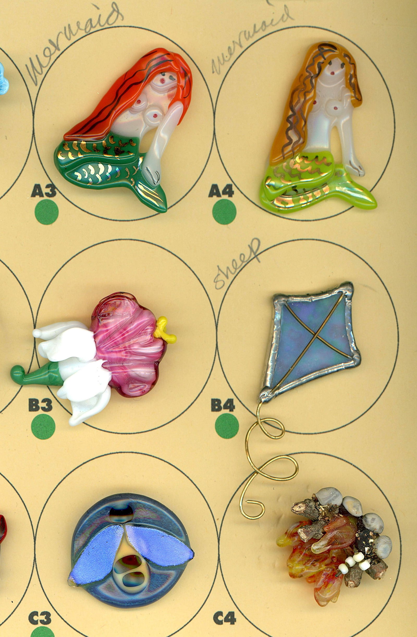 A PARTIAL CARD OF DIVISION THREE GLASS BUTTONS: 6 Medium/Large 20th/21st century colorful lampwork examples. This fun lot from the eclectic collection of Nikki Deal includes a variety of subject matter in realistic shapes and colorful lampwork desi
