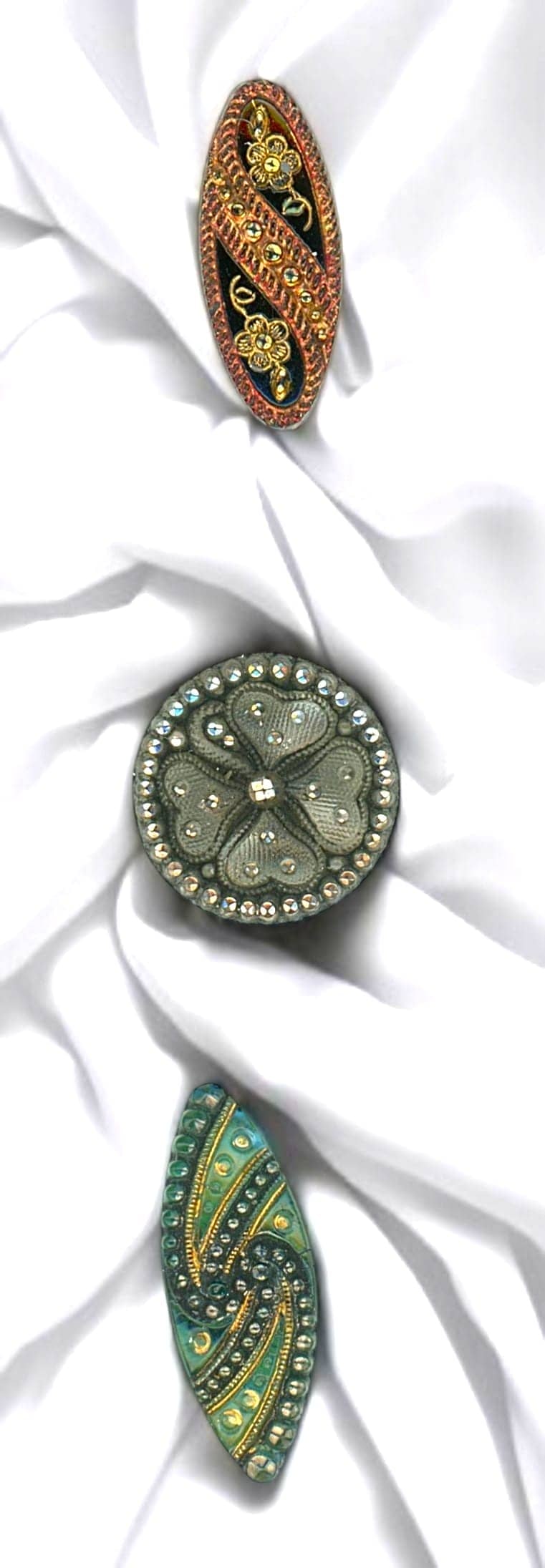 A SMALL CARD OF DIVISION ONE GLASS BUTTONS: 3 Small 19th century including spindle shaped lacy examples. Here are three beautiful Lacy glass examples from the late 1900's from the Czech republic. Lacy glass has always been a desirable button