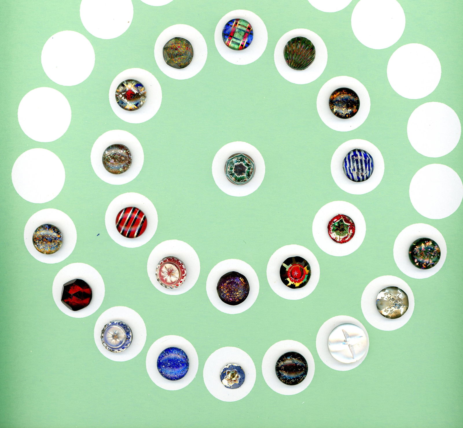 A PARTIAL CARD OF DIVISION ONE COLORFUL GLASS BUTTONS: 21 Small 19th century metal backed kaleidoscope examples. This card includes a wonderful array of colors, fancy tops and more. Notice the nice colorful realistic shell shape example. DimensionsSM=Less