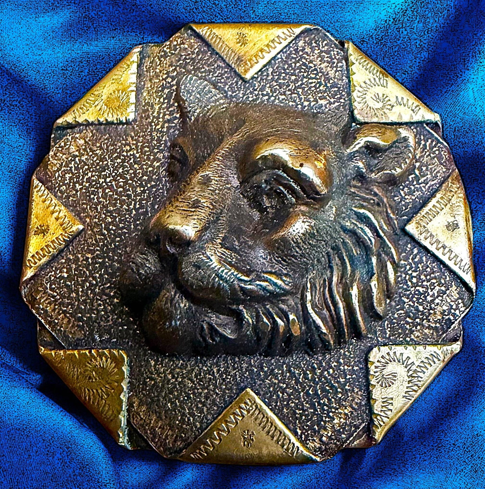 A DIVISION ONE HIGH RELIEF ANIMAL HEAD BUTTON: 1 Large 19th century Handkerchief corner lioness button. This beautifully detailed high relief head of a lioness is escutcheoned onto a textured background with 8 handkerchief engraved corners. A beau