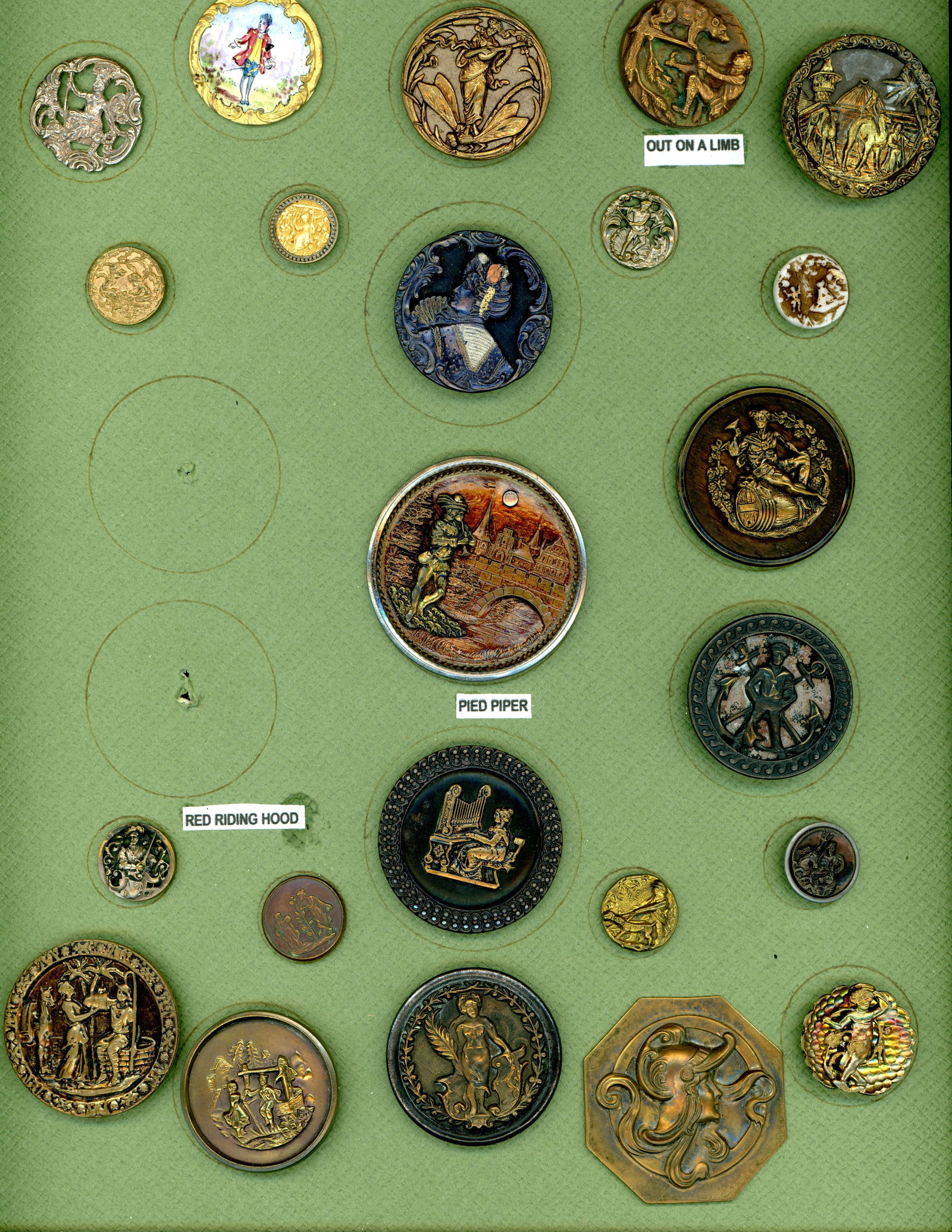 A CARD OF DIVISION ONE PICTURE BUTTONS: 23 S/M/L 19t/20th C. mostly brass including some scarce examples. This nice card includes the Art Nouveau design of the women playing a mandolin and riding a dragonfly, St Cecelia at the Organ, a poly