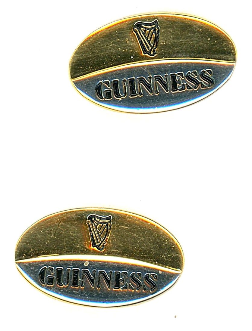 A SMALL CARD OF BRANDE RELATED ADVERTISING BUTTONS: 2 Medium oval 20th century examples of the Guiness Beer Co. These two buttons advertise the name of the Irish Beer company, Guiness engraved on a brass oval. These are not at all common for button col