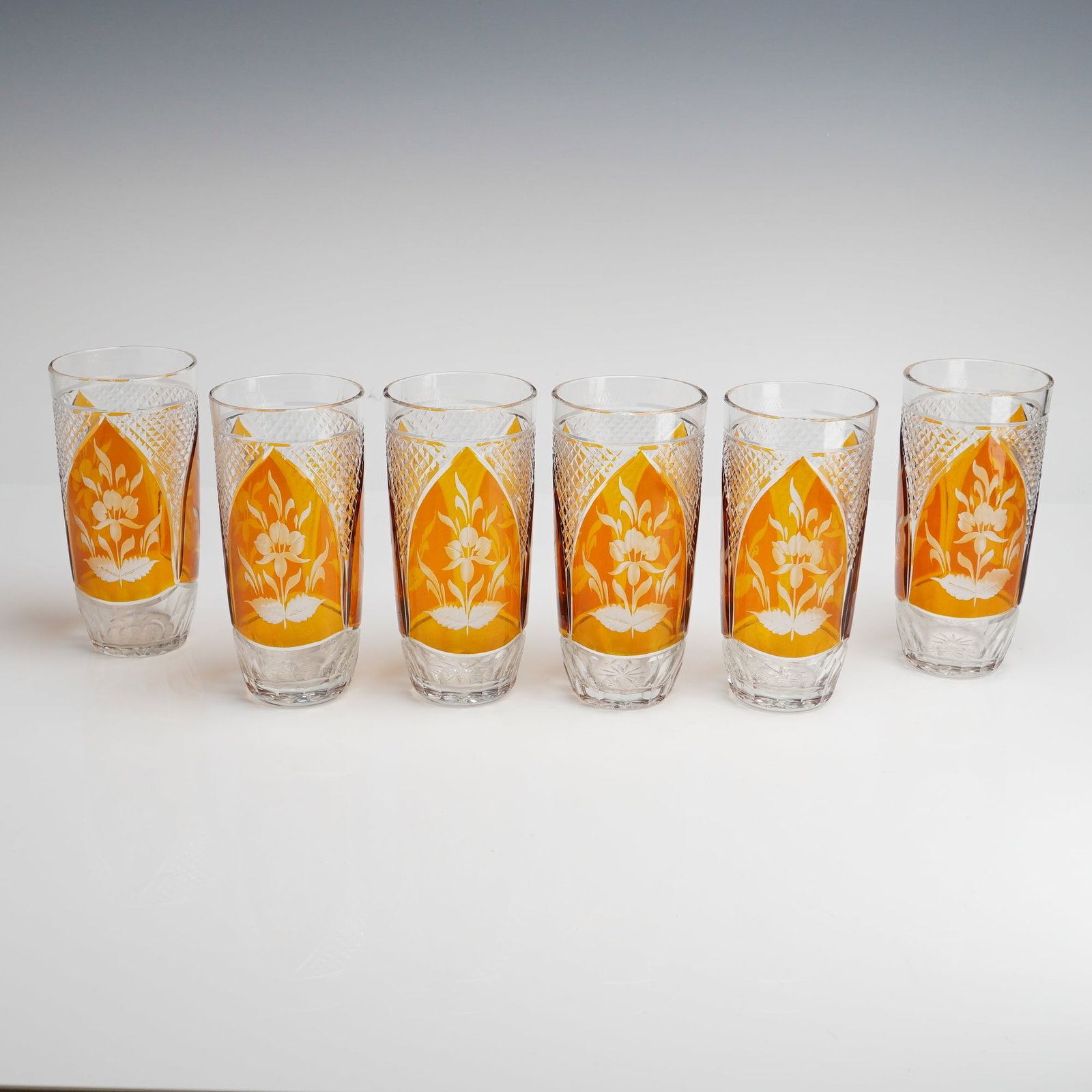 Bohemian Amber Cut-to-Clear Etched Floral Crystal Highball Glasses: This set of six Bohemian cut-to-clear highball glasses represents the fine craftsmanship of mid-20th-century Czech lead crystal production. Each glass is expertly constructed with a thick layer of vib