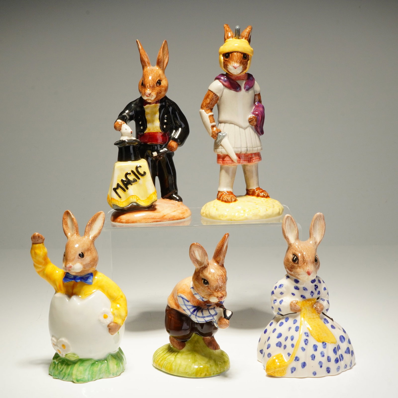 5pc Royal Doulton Bunnykins Figurines: A collection of five Royal Doulton Bunnykins ceramic figurines. These hand-painted figures feature a high-gloss glaze and depict various anthropomorphic rabbits in themed attire. The group includes Ma