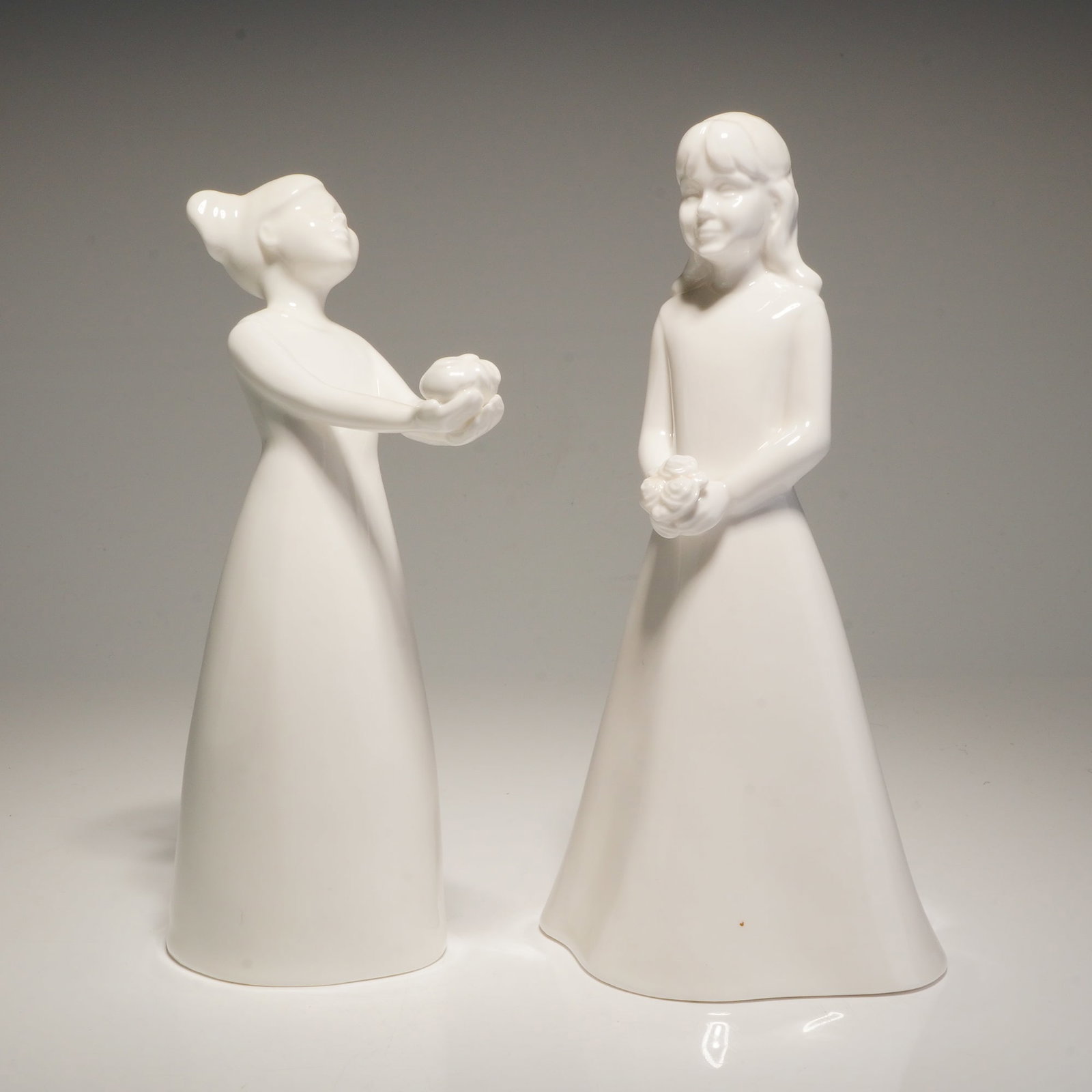 2pc Coalport Moments Bone China Figurines, Special Gift and The Bridesmaid: Two Coalport bone china figurines from the Moments collection. The figurine titled The Special Gift depicts a young girl with hair styled in pig tails holding a gift, with the Coalport mark on the bas