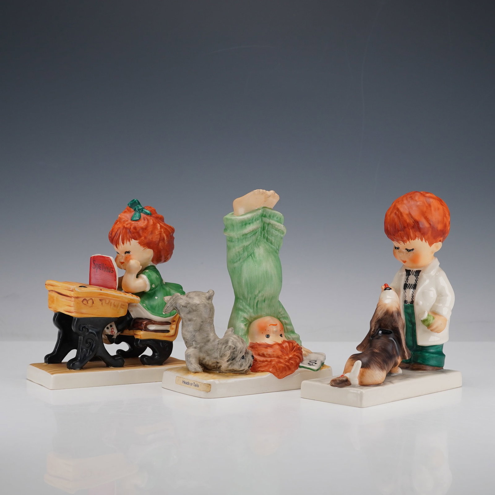 3pc Goebel Charlot Byj Assorted Children Figurines: Three hand painted adorable children figurines including Say A-A-A-AAH, Spellbound, and Heads or Tails. Depicts red head children in various poses. Charlot Byj stamped to base. Goebel backstamp. Dimen